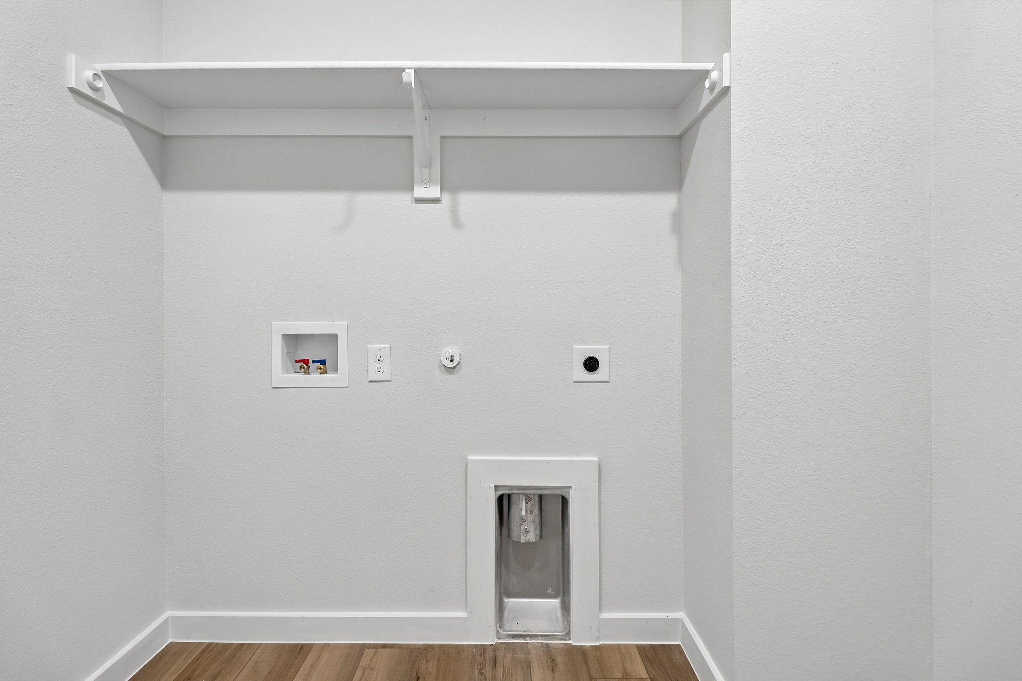A white wall with a light fixture.