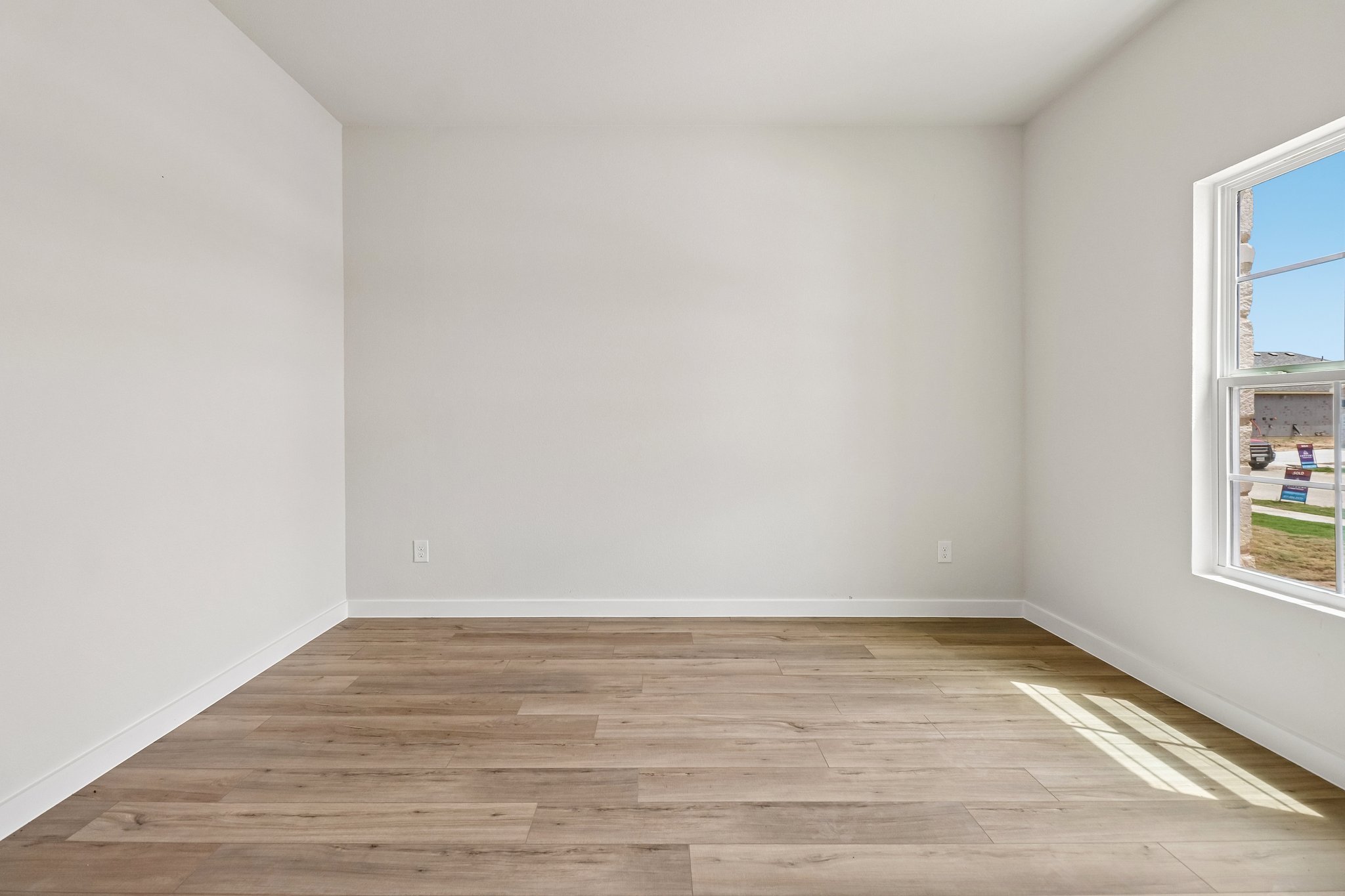 A room with a wood floor and a window.
