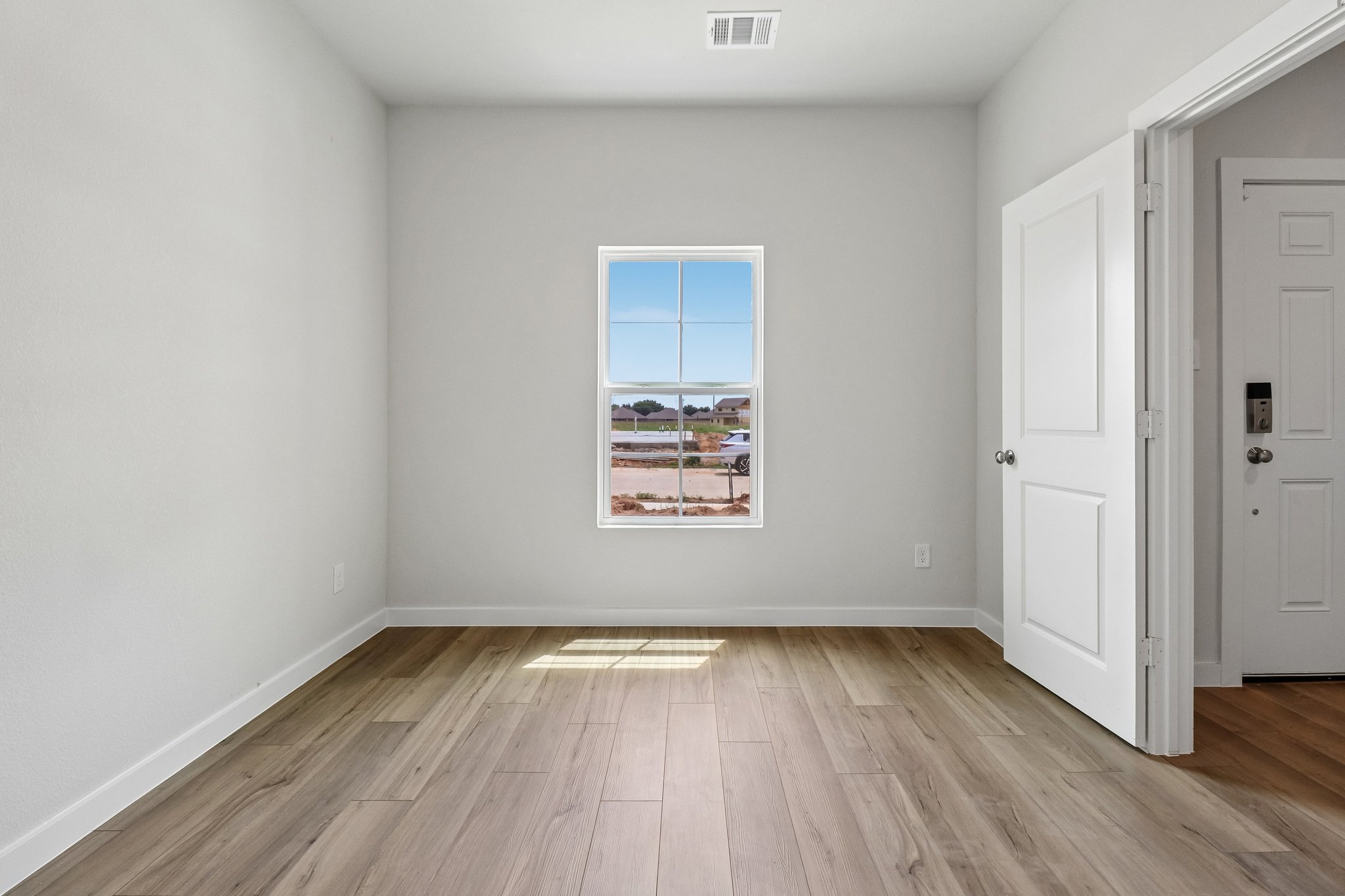 A room with white doors and a wood floor.