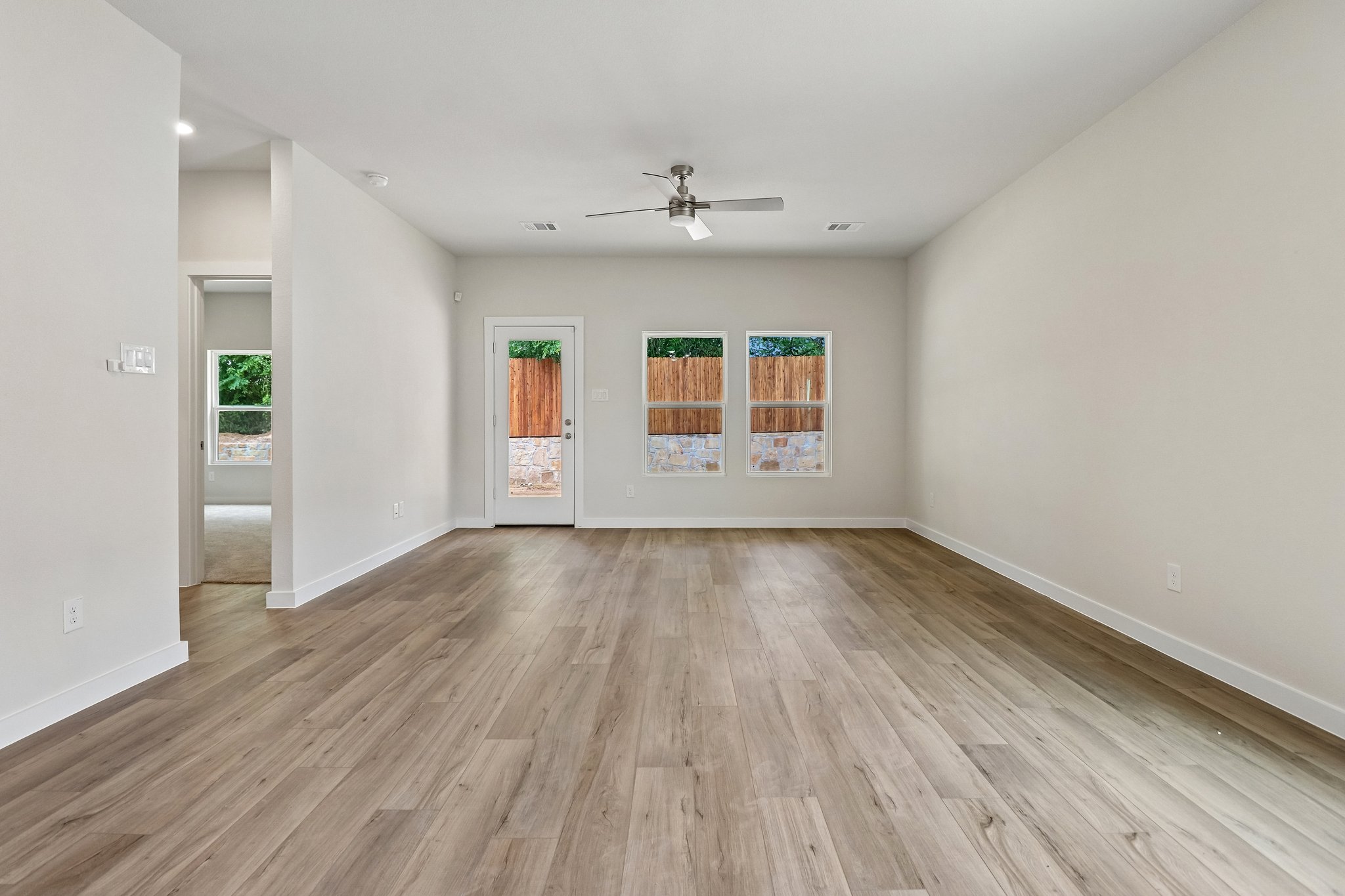 A room with a wood floor and a ceiling fan.