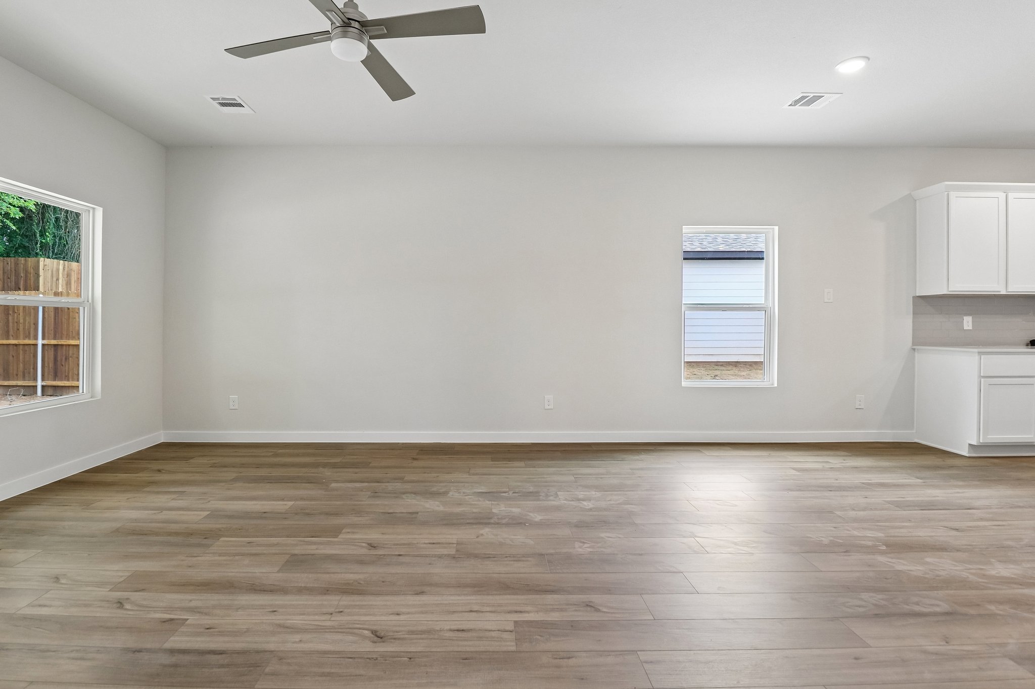 A room with a wood floor and a ceiling fan.