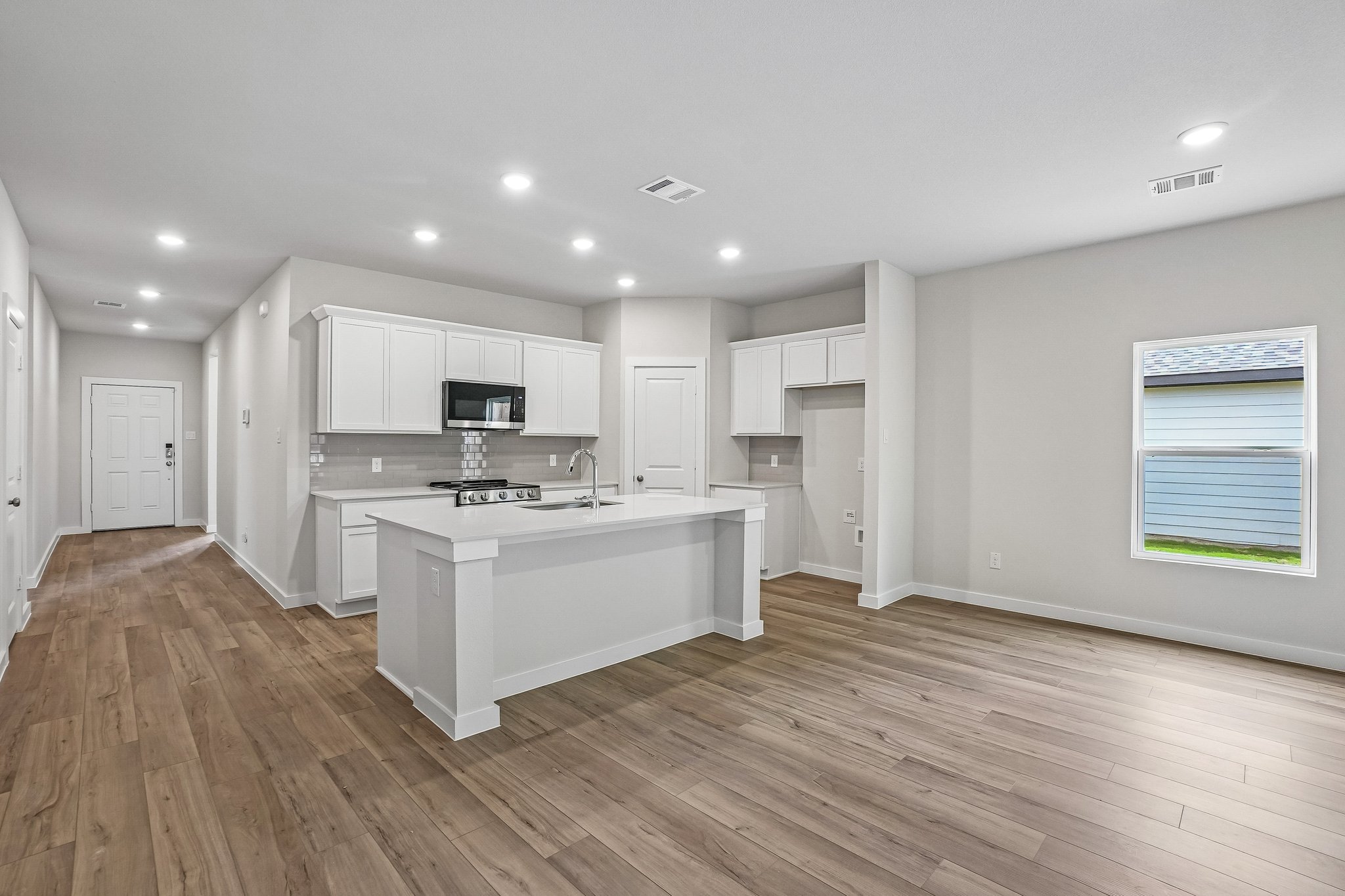 A kitchen with white cabinets.