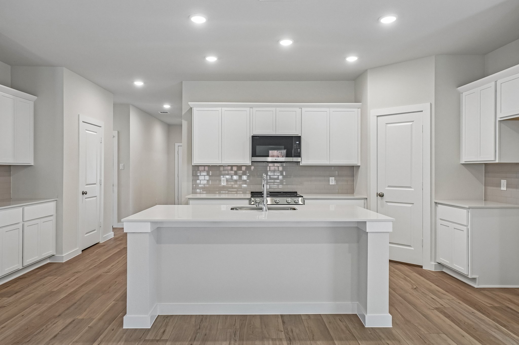 A kitchen with white cabinets.