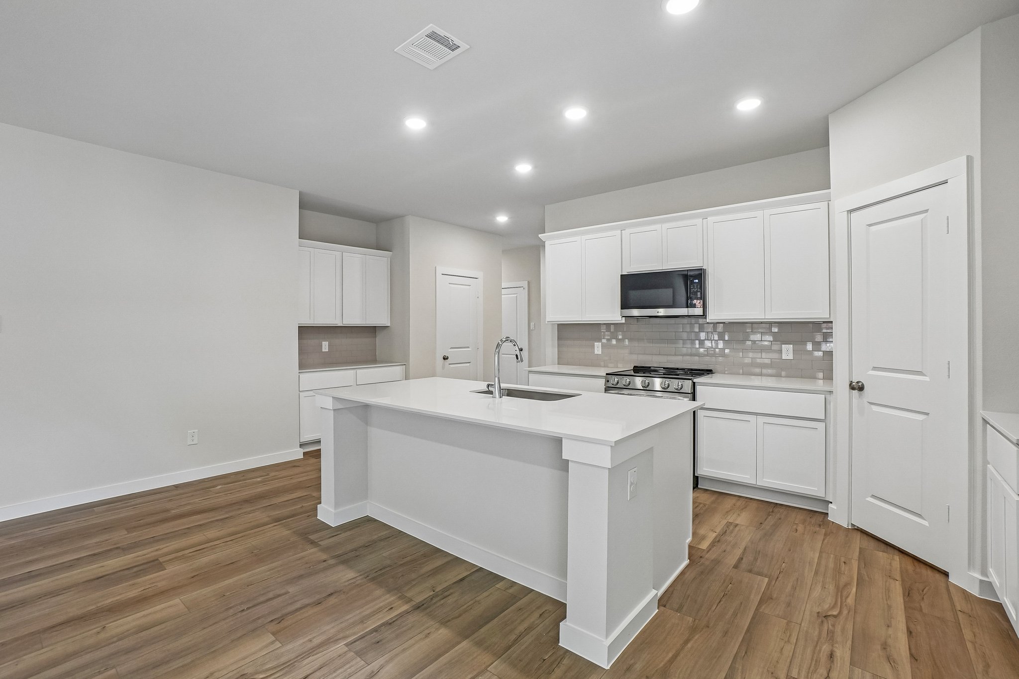 A kitchen with white cabinets.