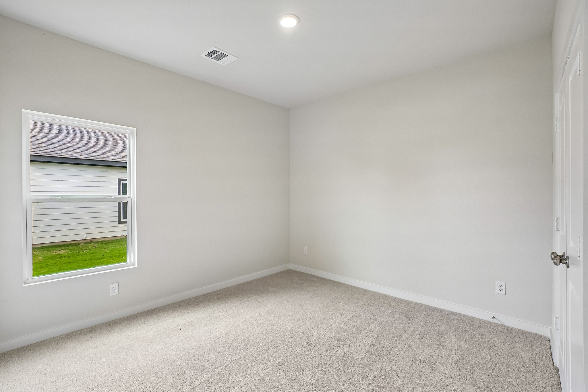A room with a window and a carpet.