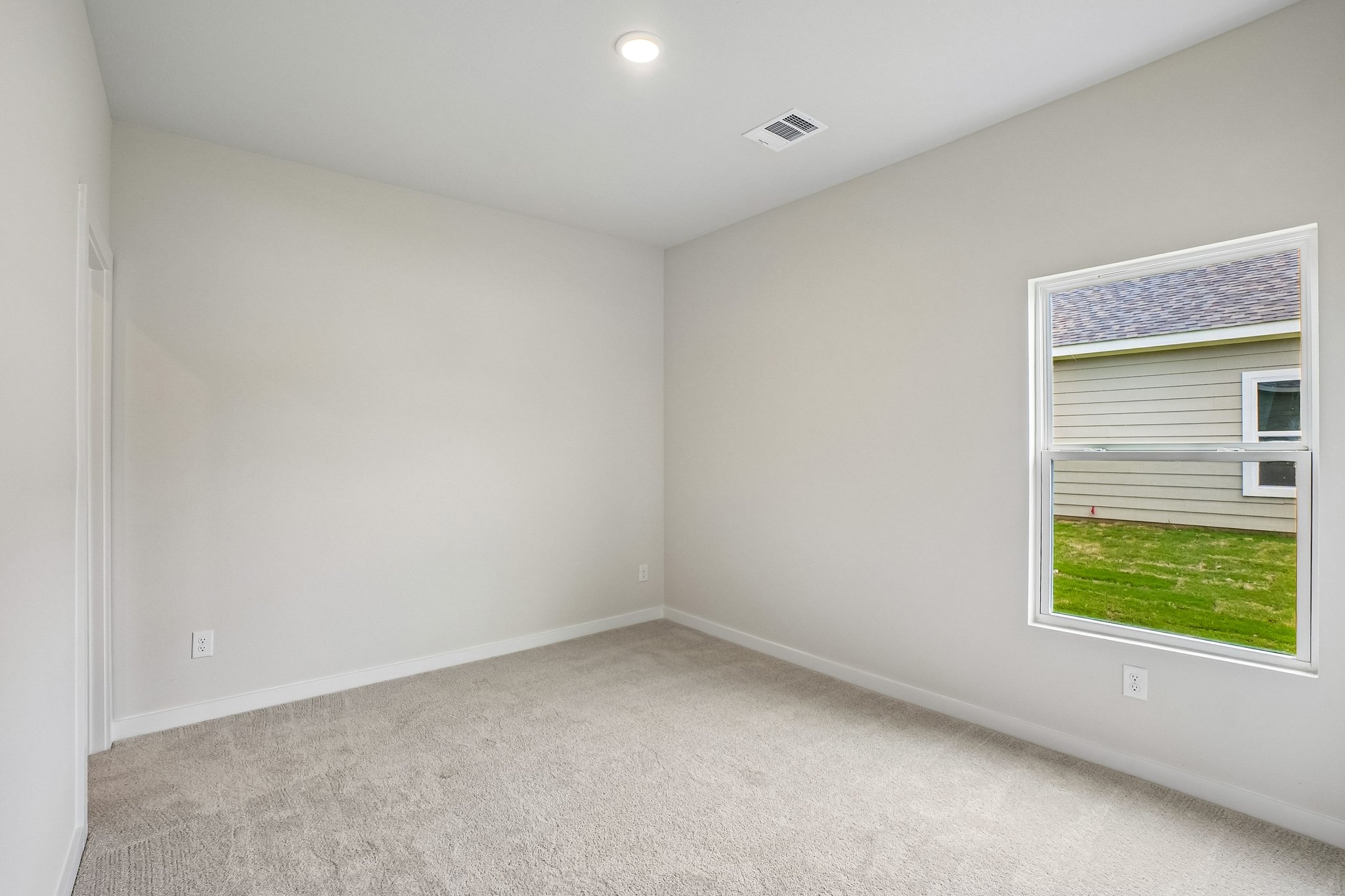 A room with a window and a carpet.