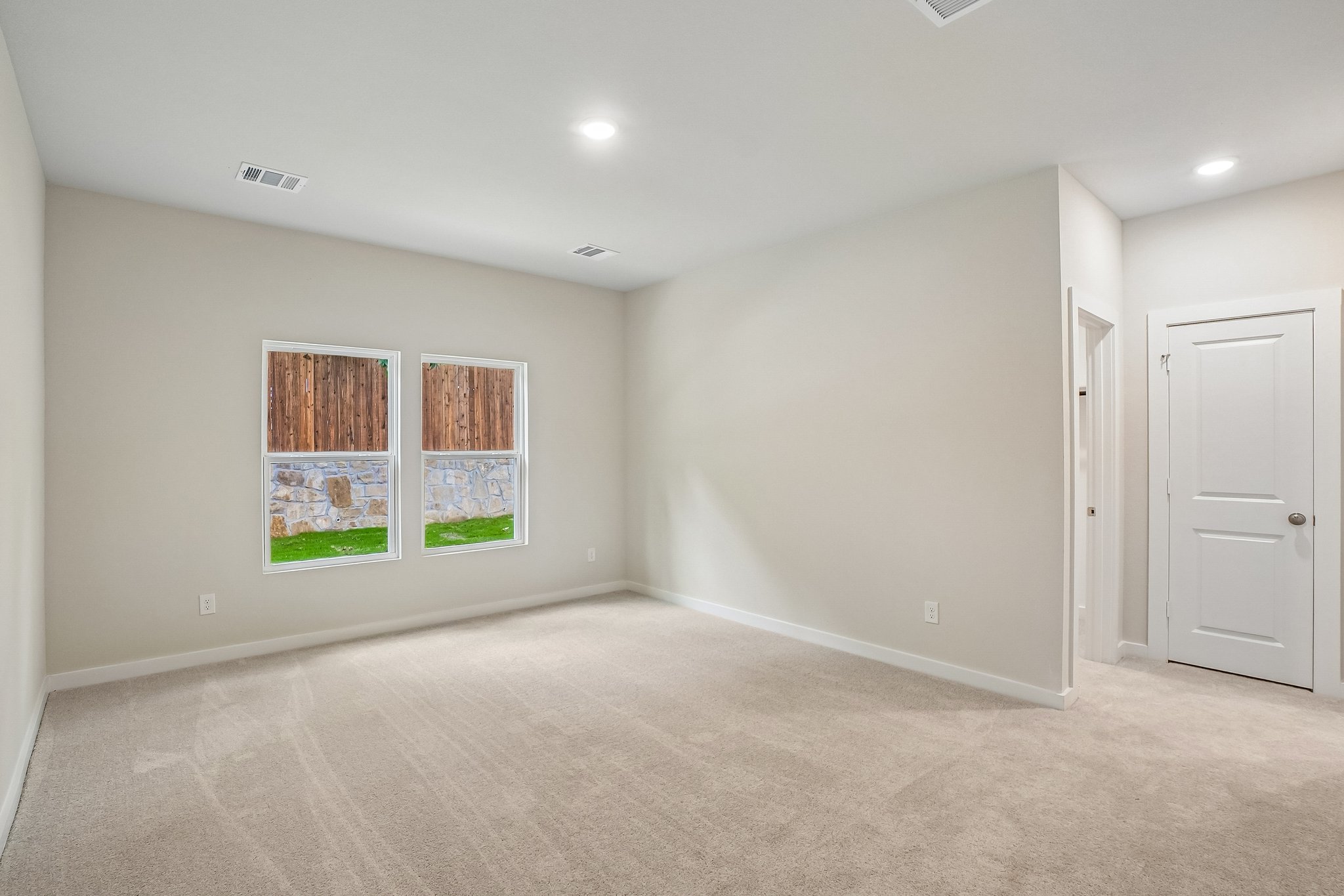 A room with a carpet and a window.