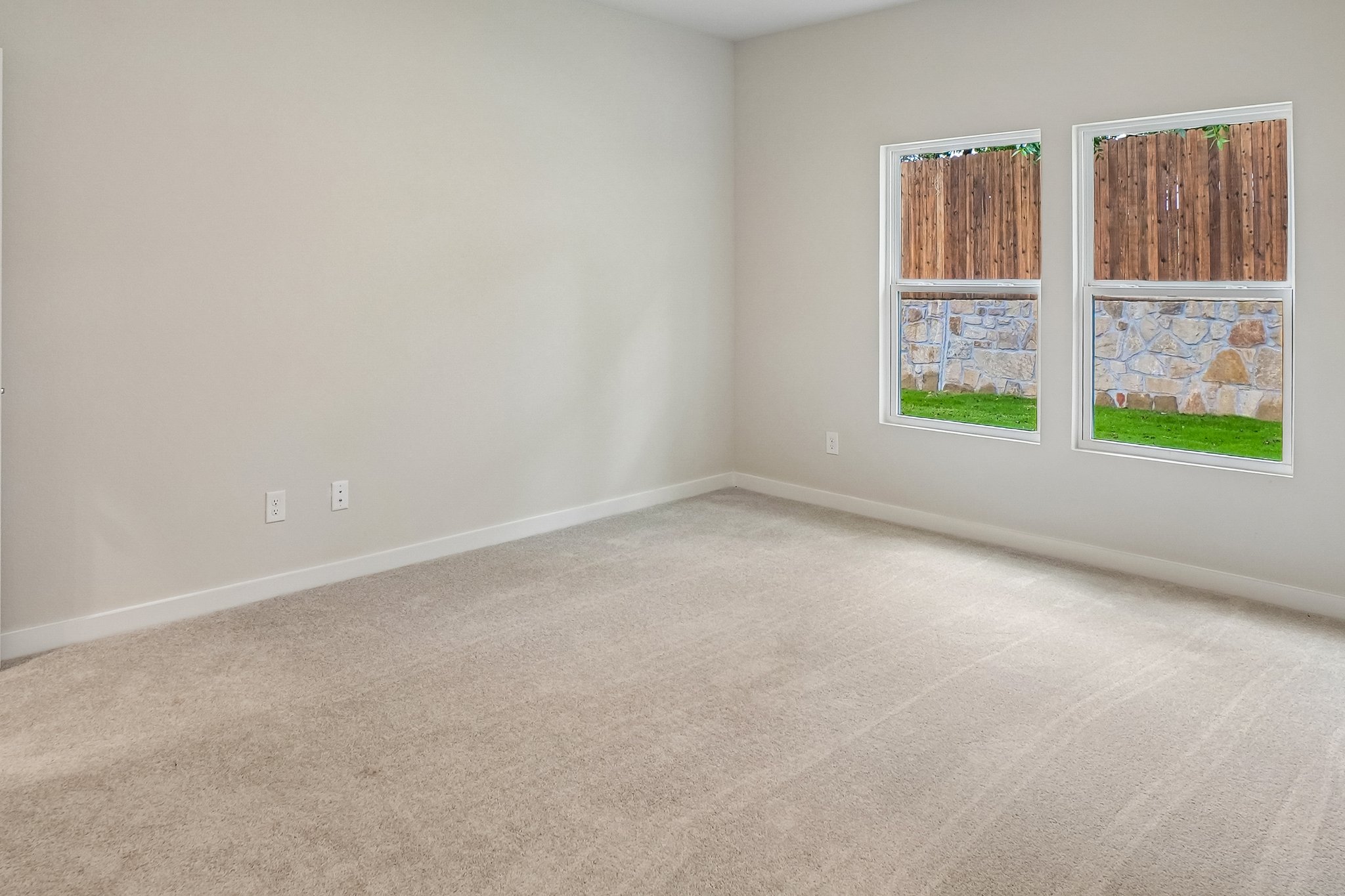 A room with a carpet and windows.