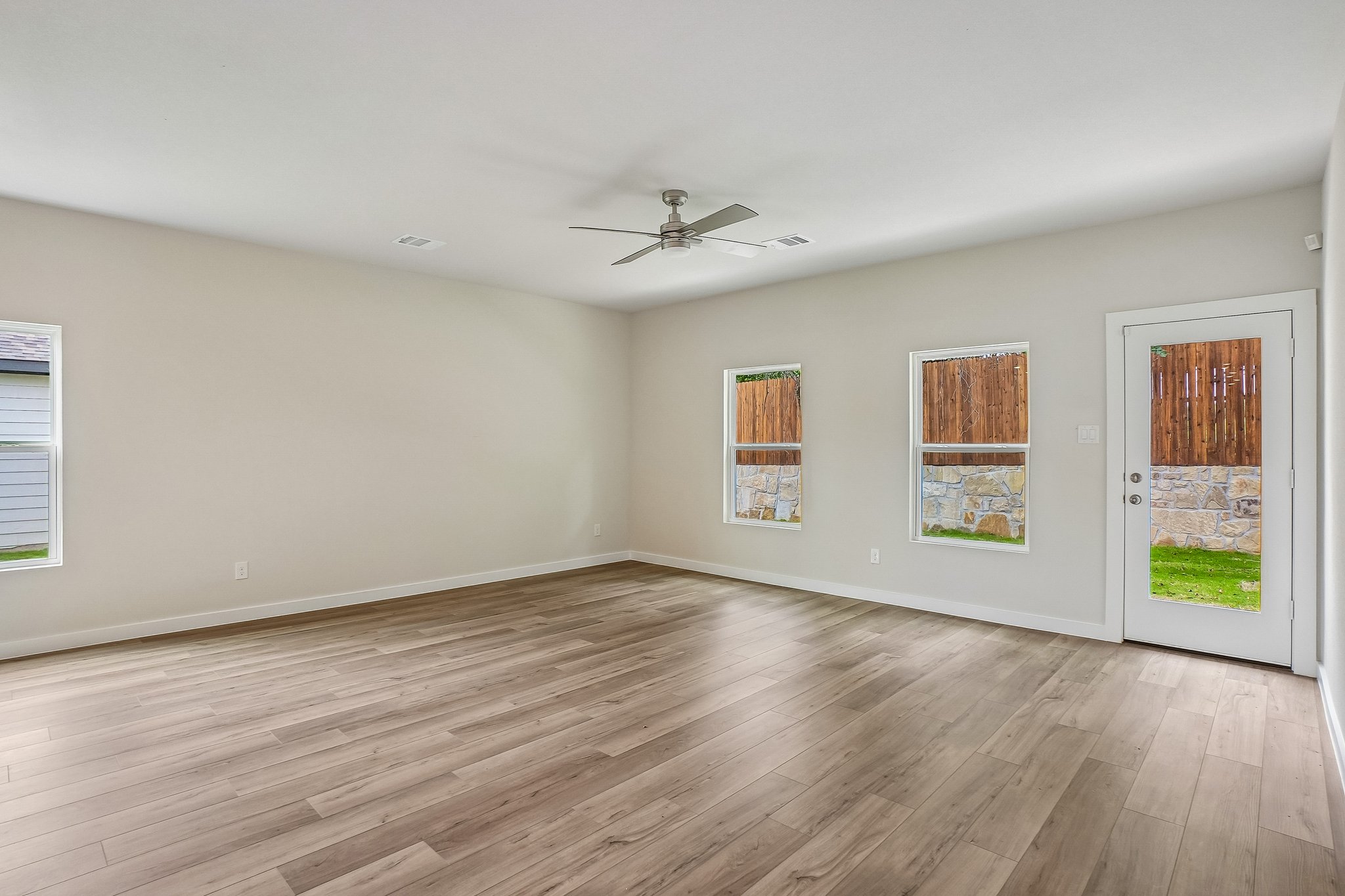 A room with a wood floor and a wood floor with a ceiling fan.