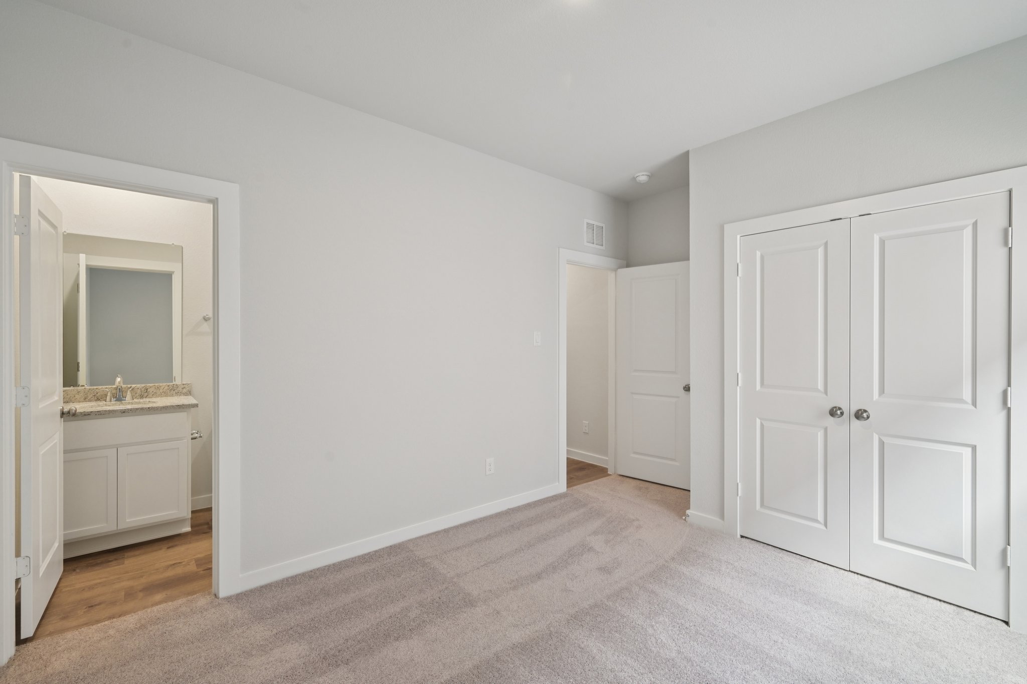 A bathroom with white cabinets.