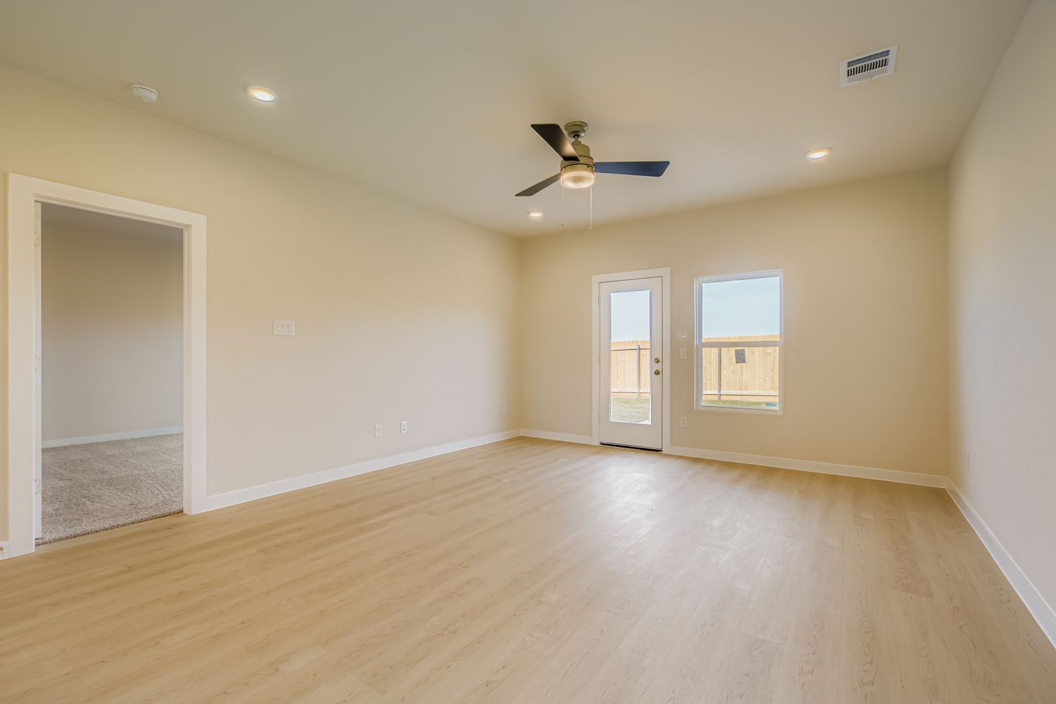 A room with a wood floor and a ceiling fan.