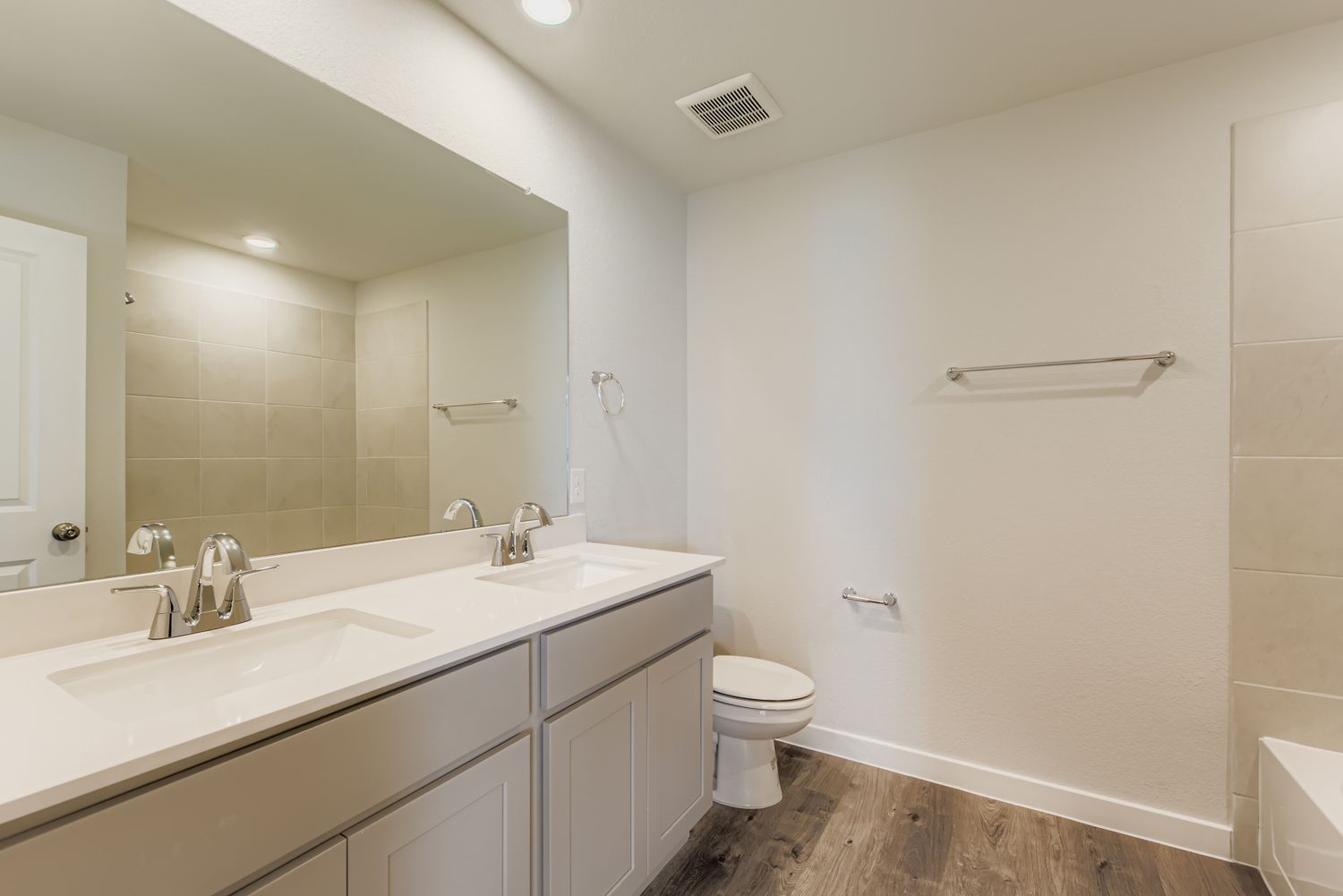 A bathroom with a large mirror.