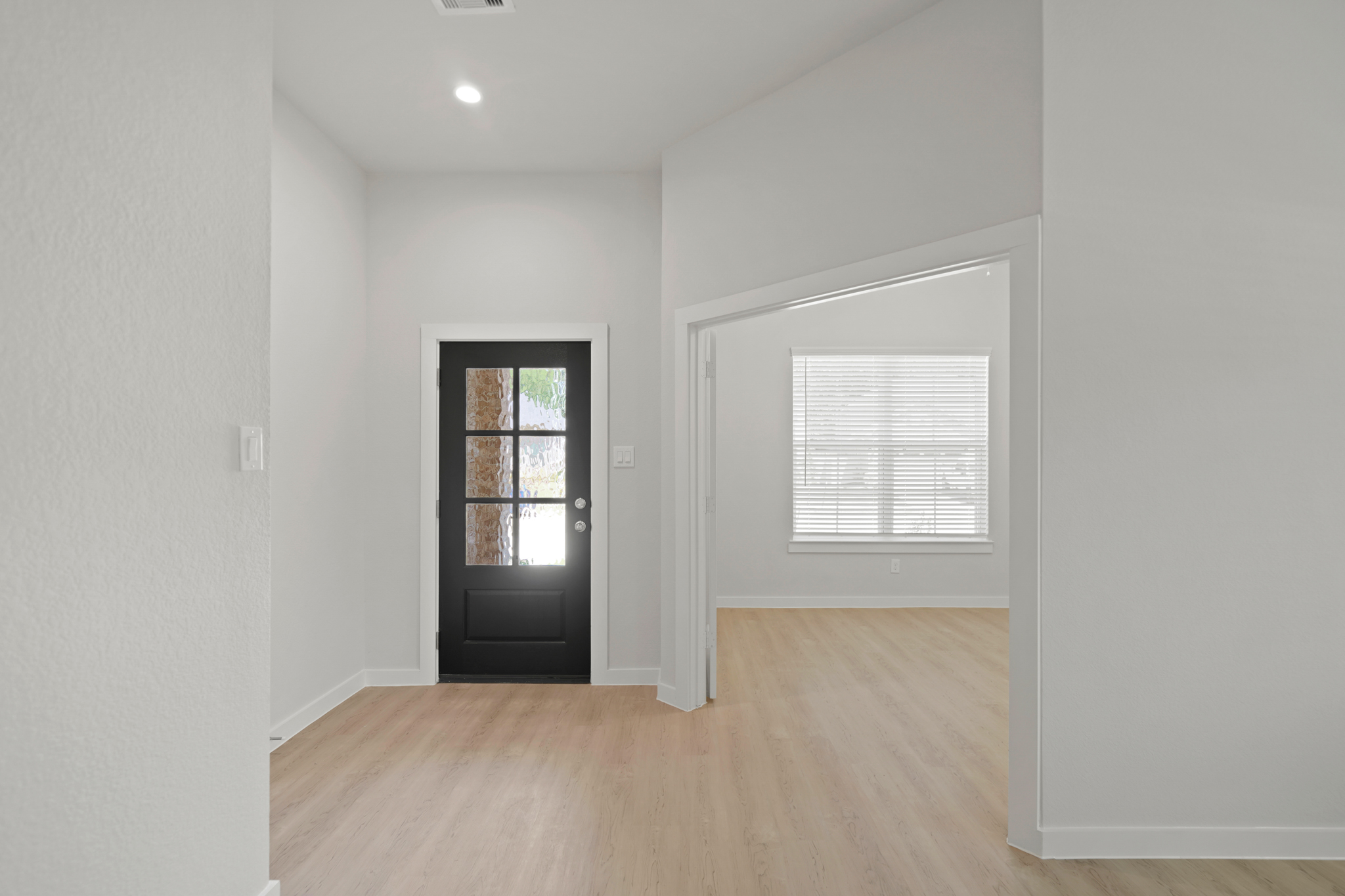 A room with a wood floor and a door with a window.