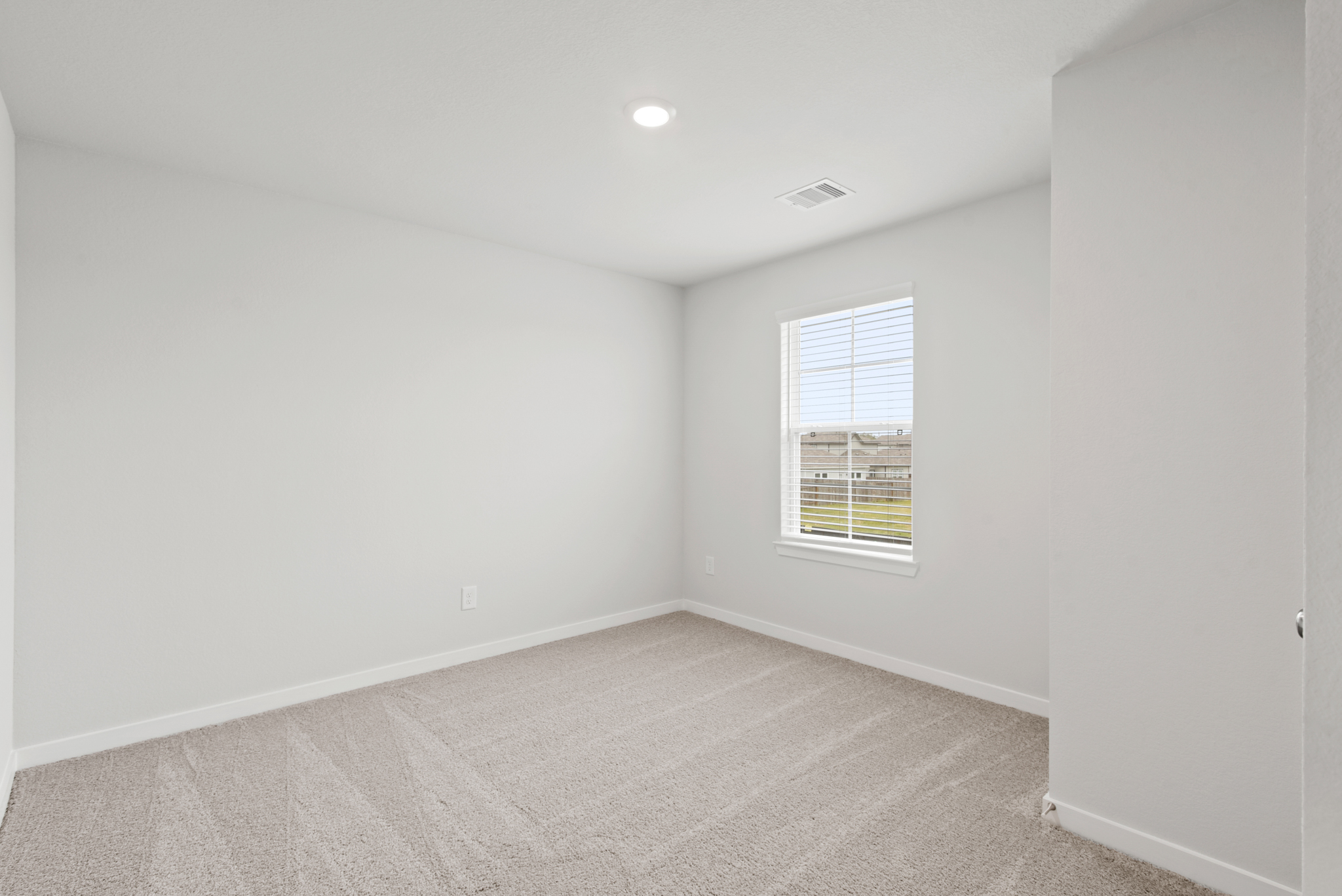 A room with a window and a carpet.