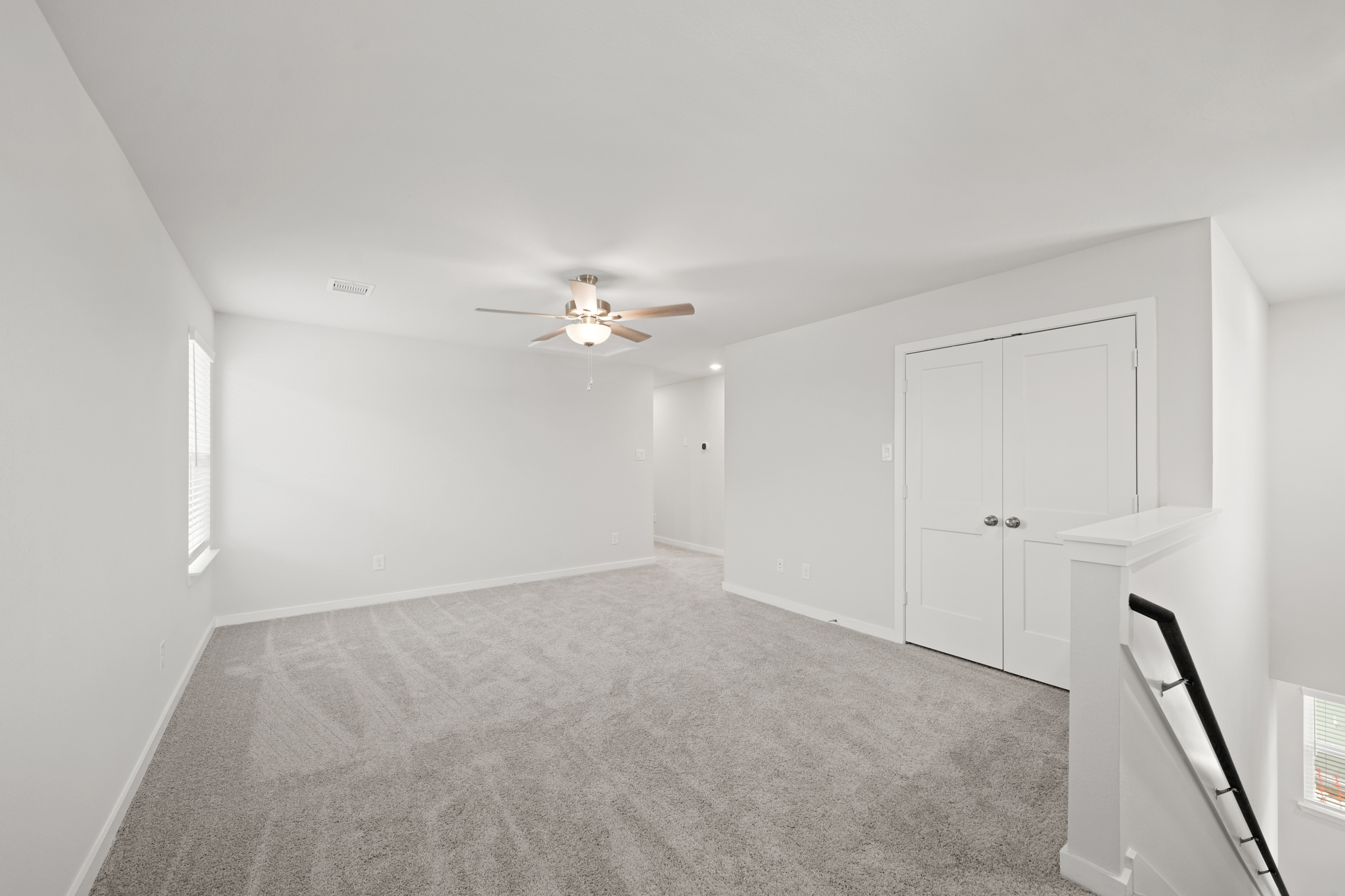 A room with white doors and a ceiling fan.