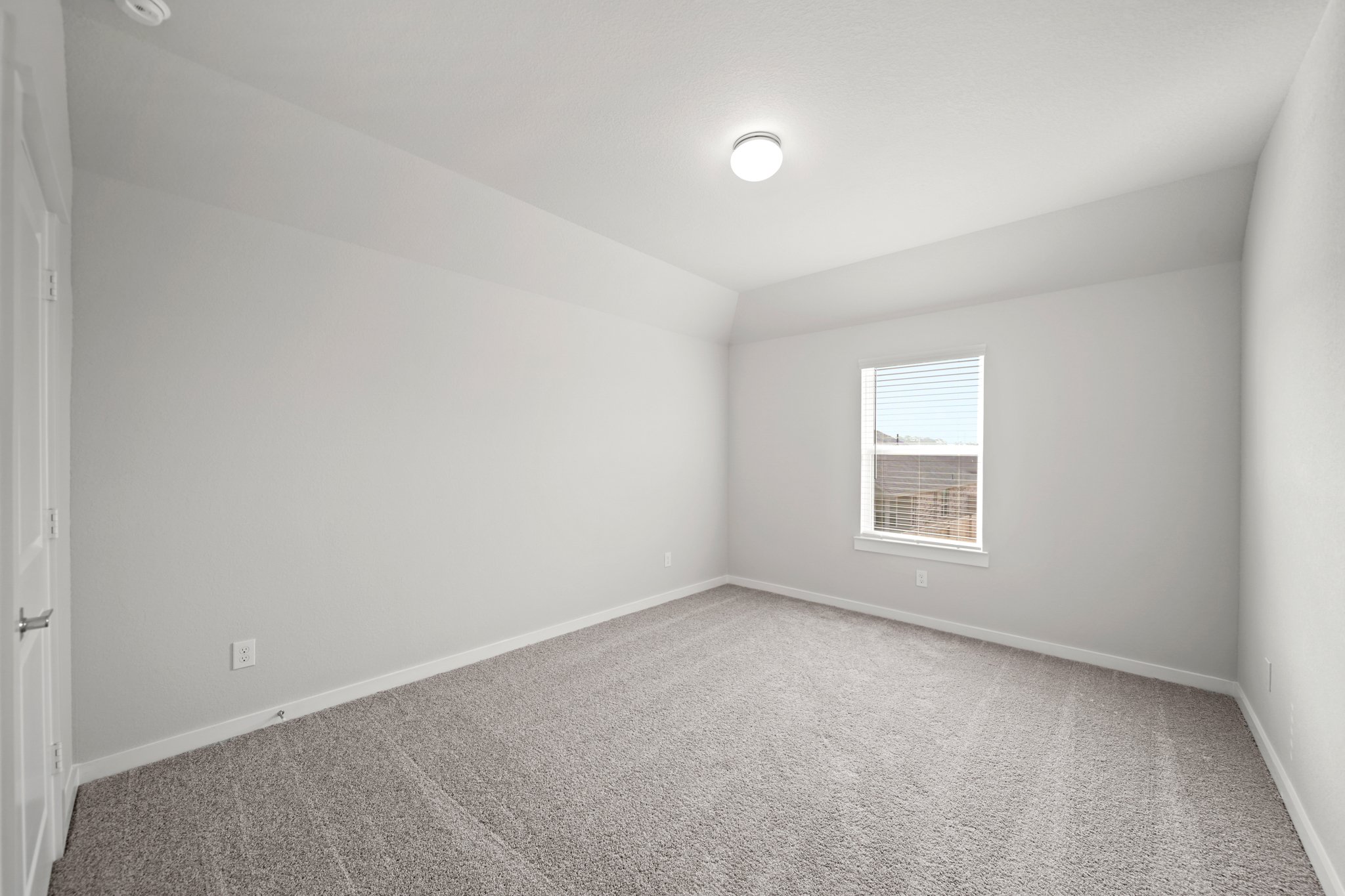 A room with a carpet and a window.