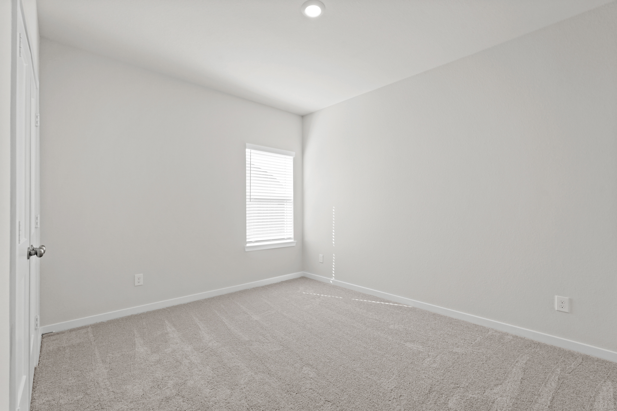 A room with a carpet and a window.