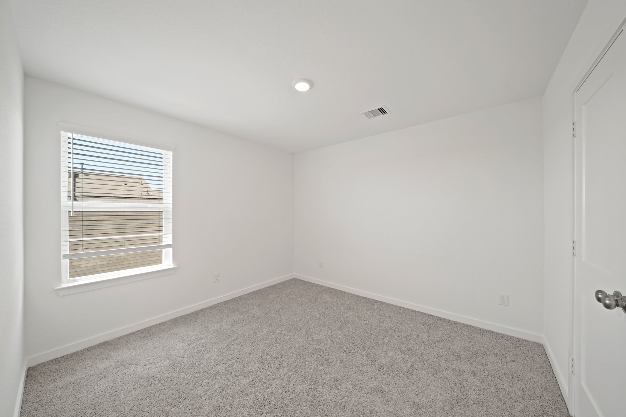 A room with a window and a carpet.