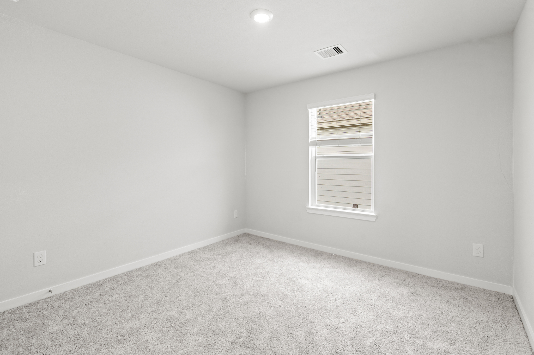 A room with a carpet and a window.