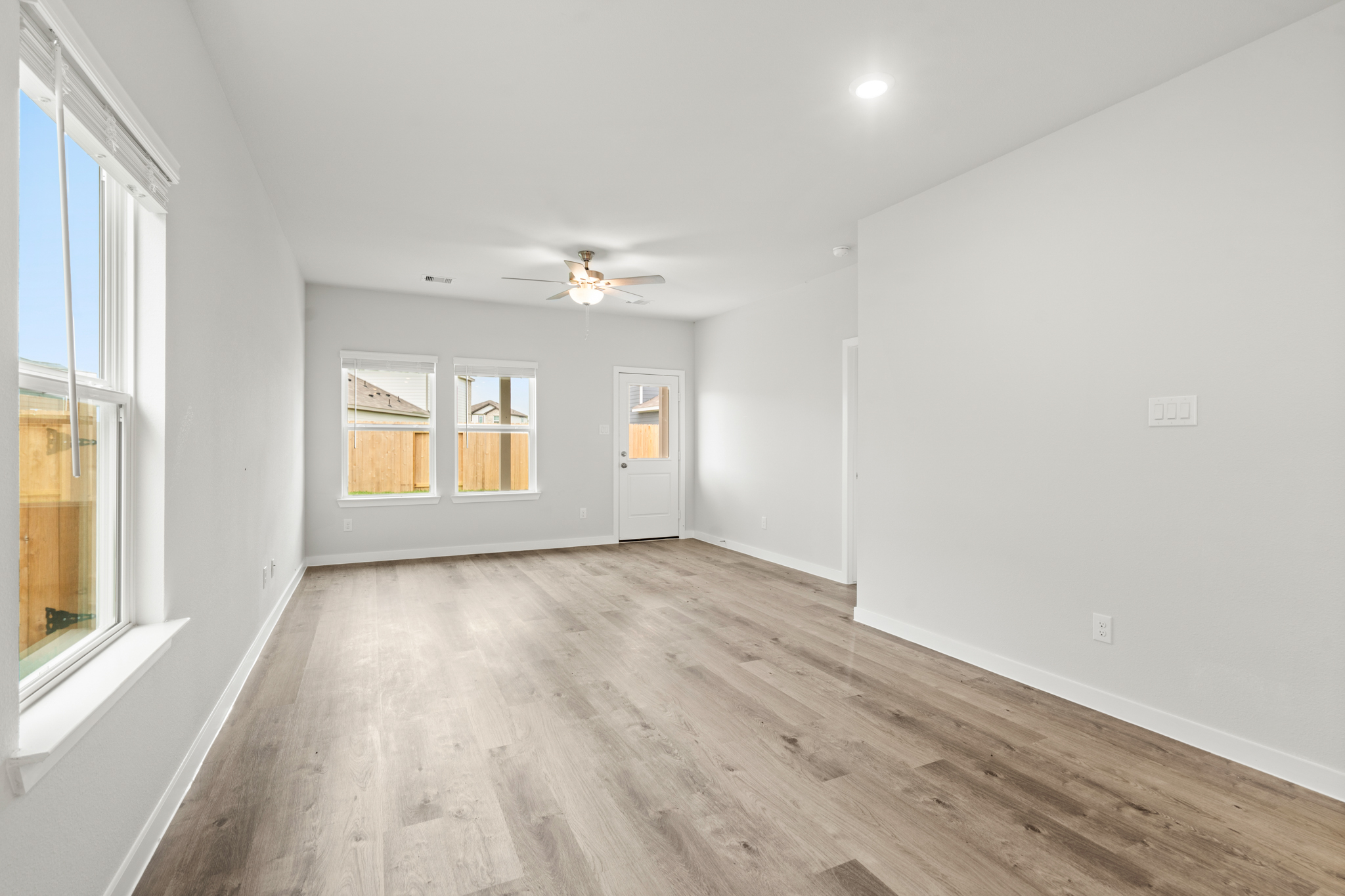 A room with a wood floor and a ceiling fan.