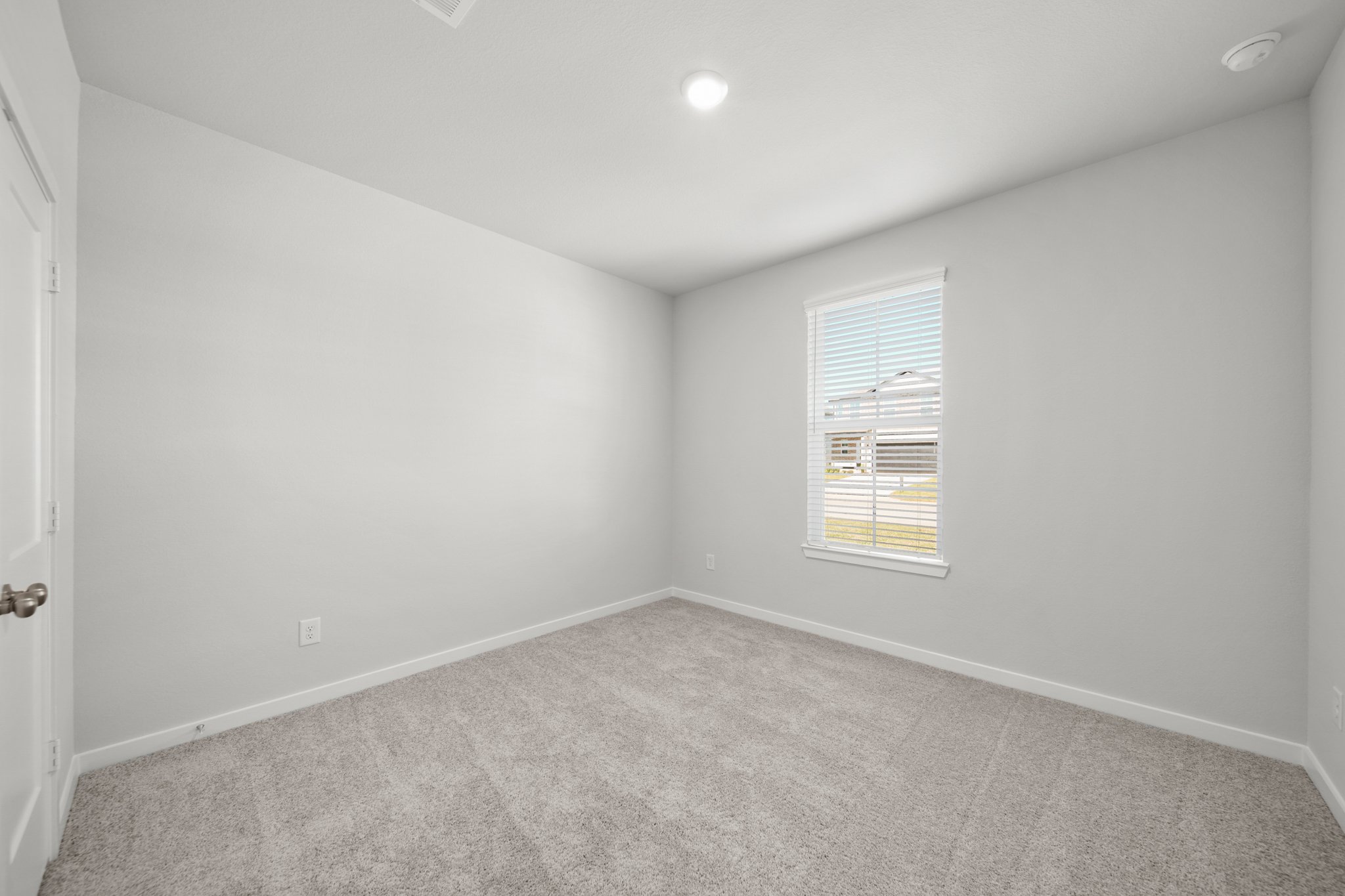 A room with a window and a carpet.