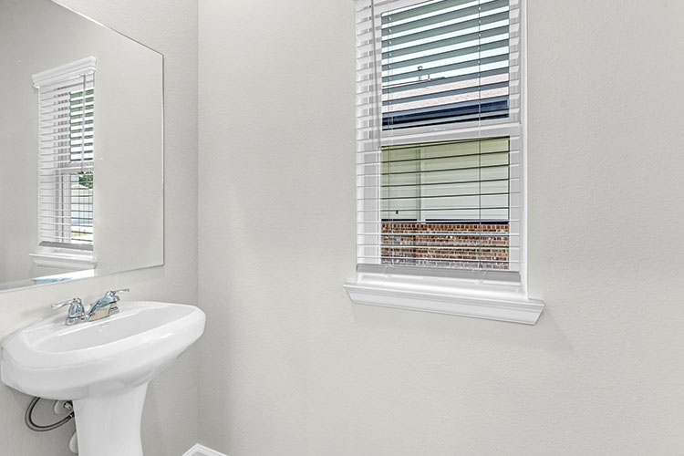 A bathroom with a sink and a window.