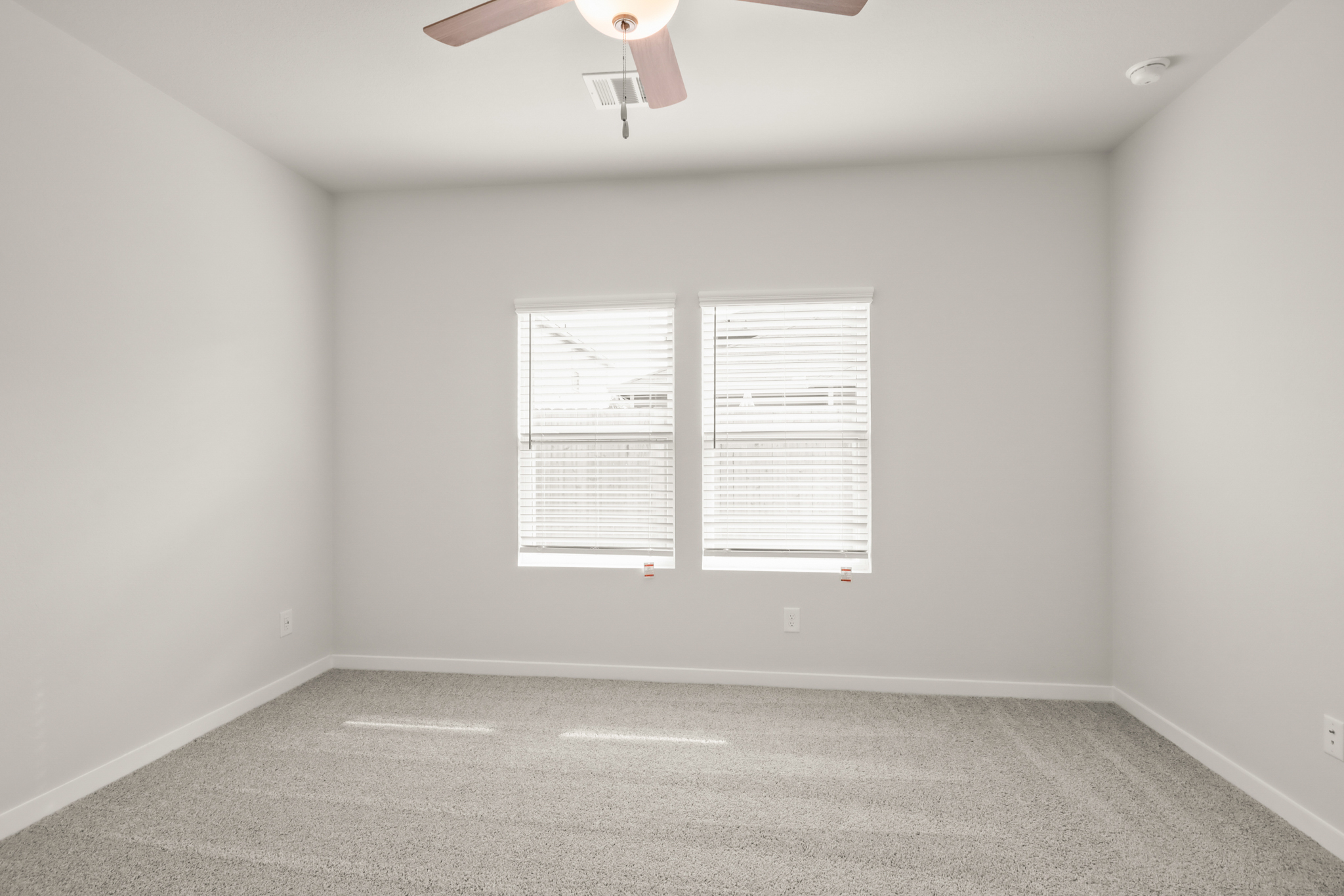 A room with a ceiling fan and a window.