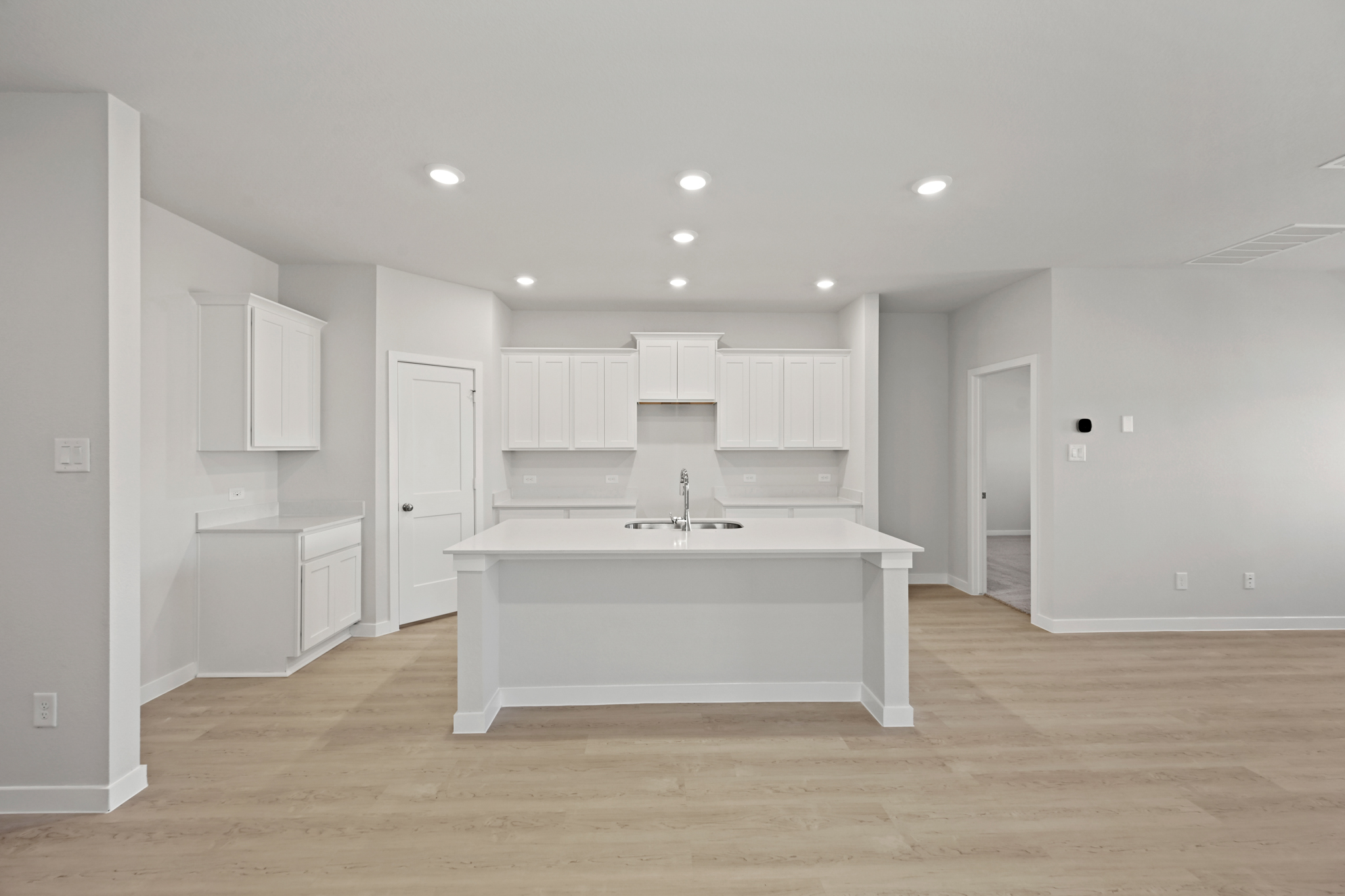 A kitchen with white cabinets.