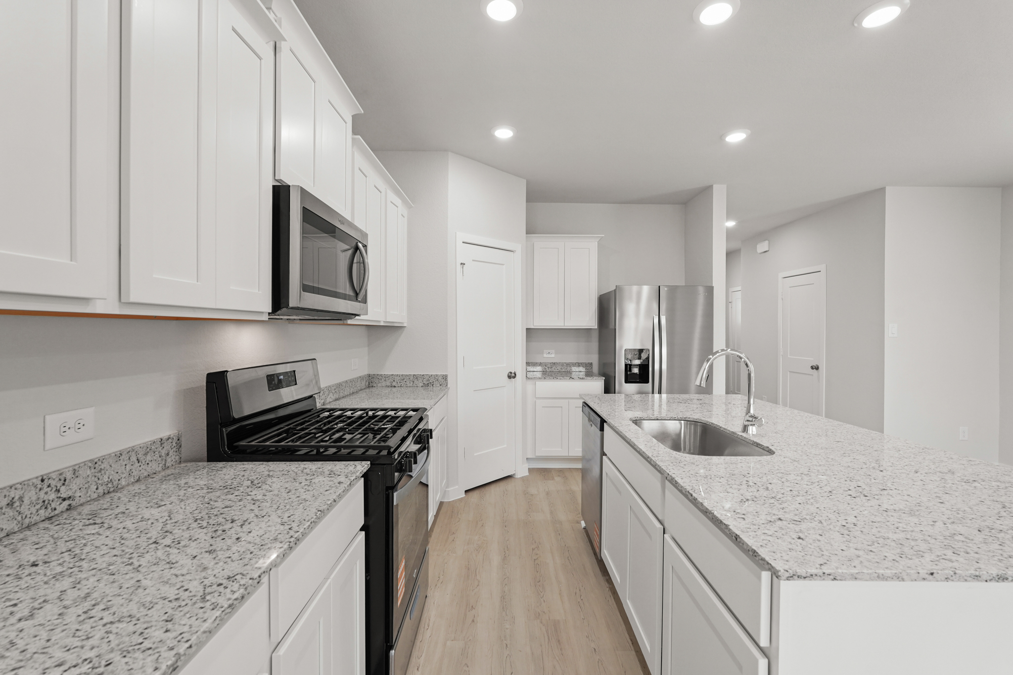 A kitchen with white cabinets.