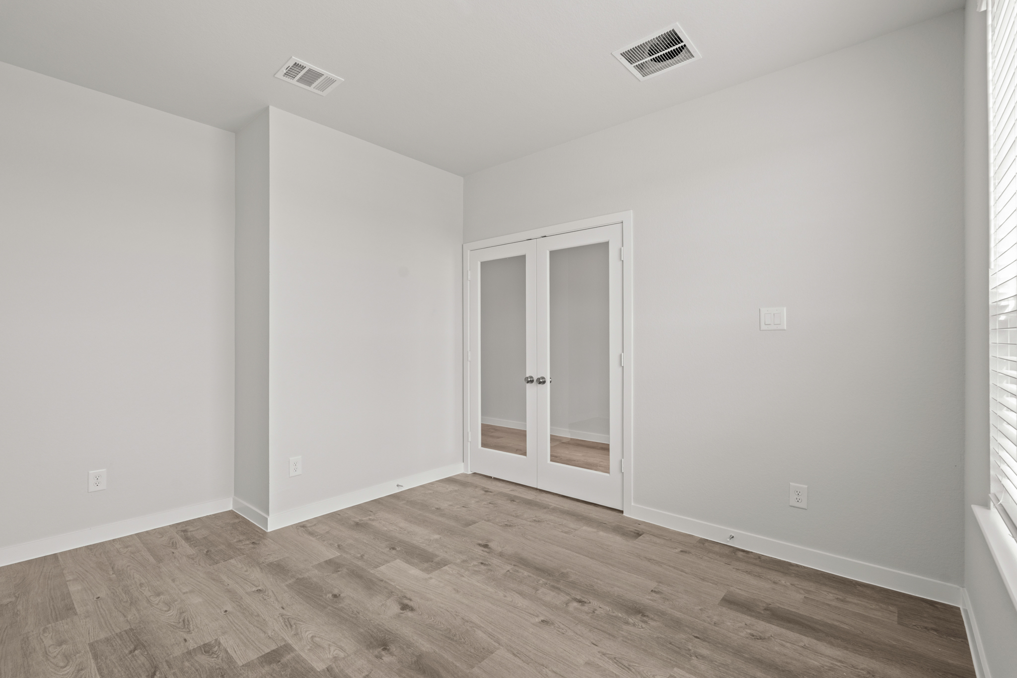 A room with a wood floor and a door.
