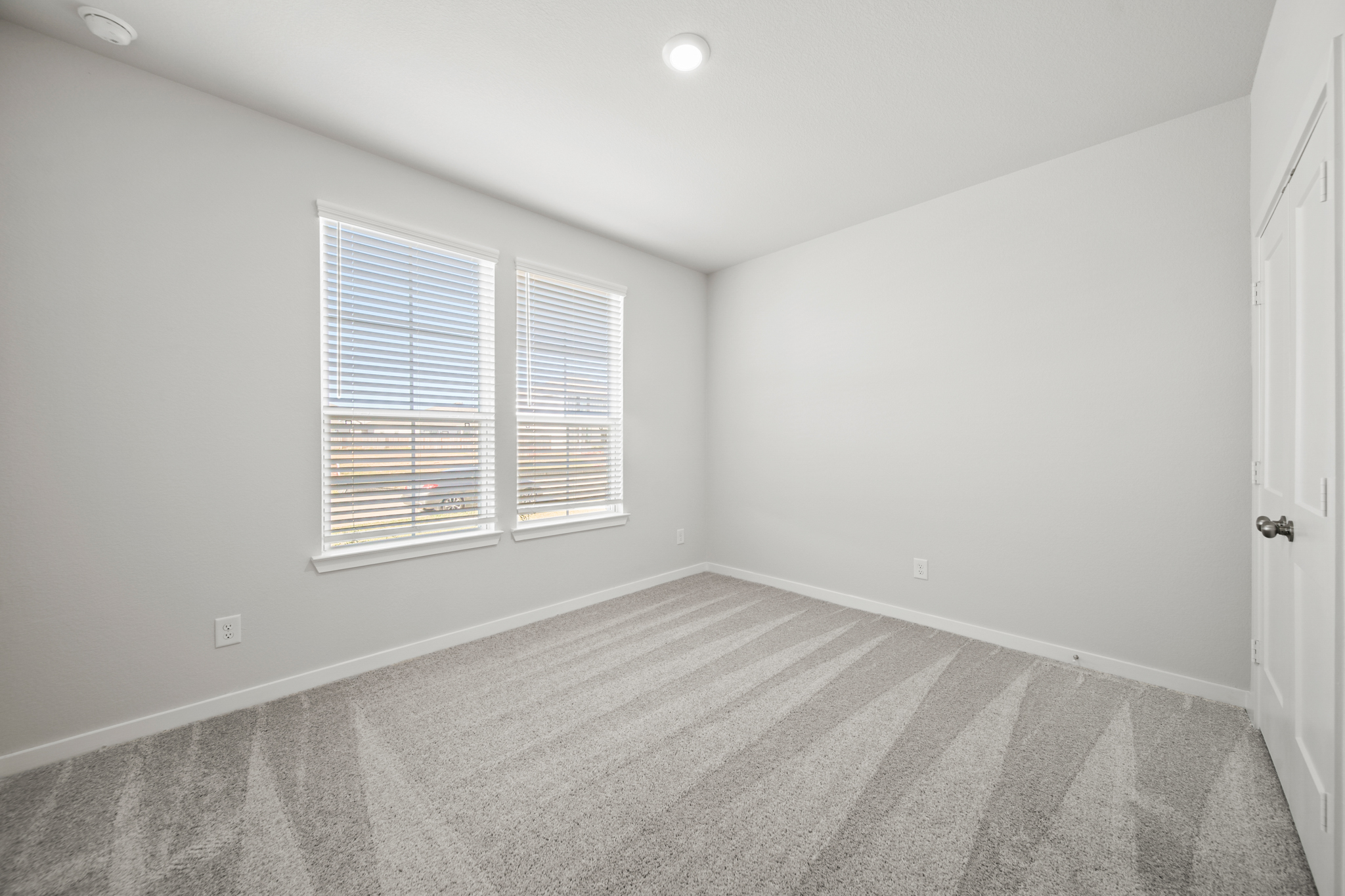 A room with a carpet and windows.