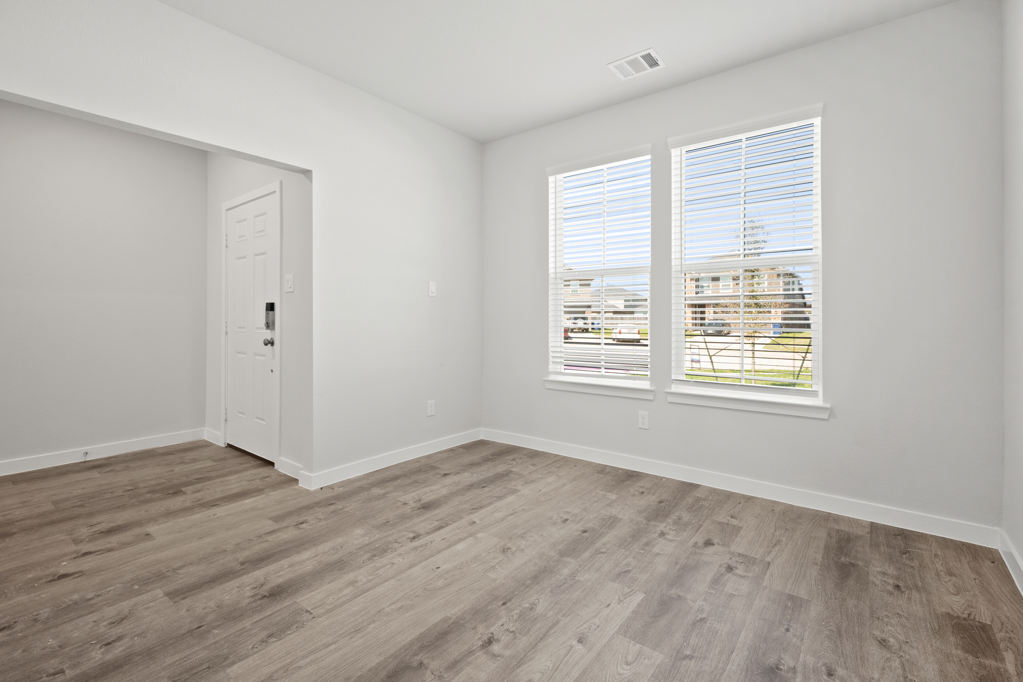 A room with a wood floor and windows.