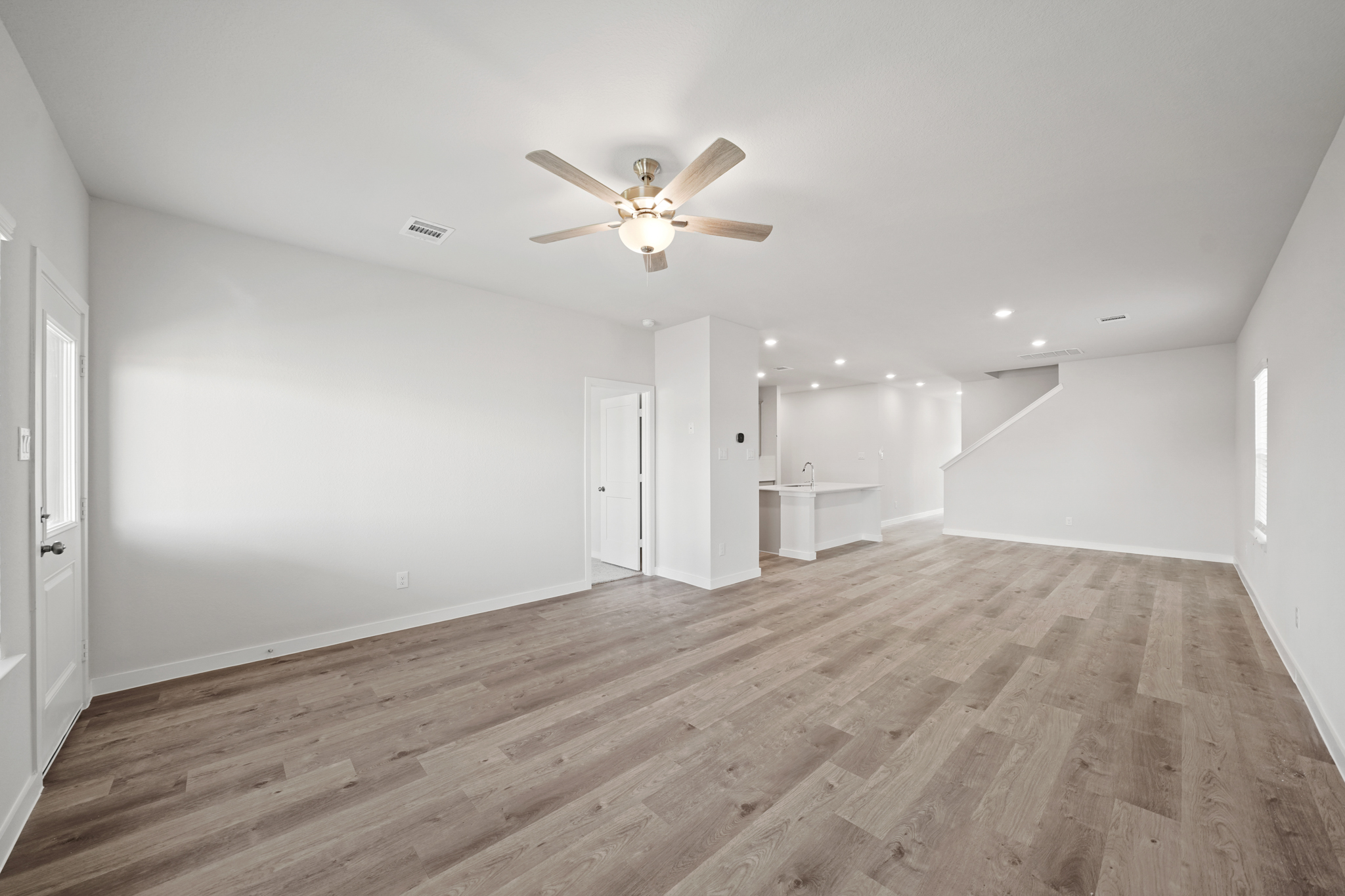 A room with a wood floor and a ceiling fan.