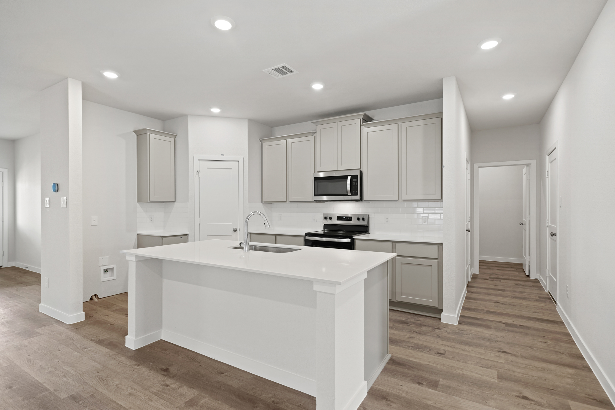 A kitchen with white cabinets.