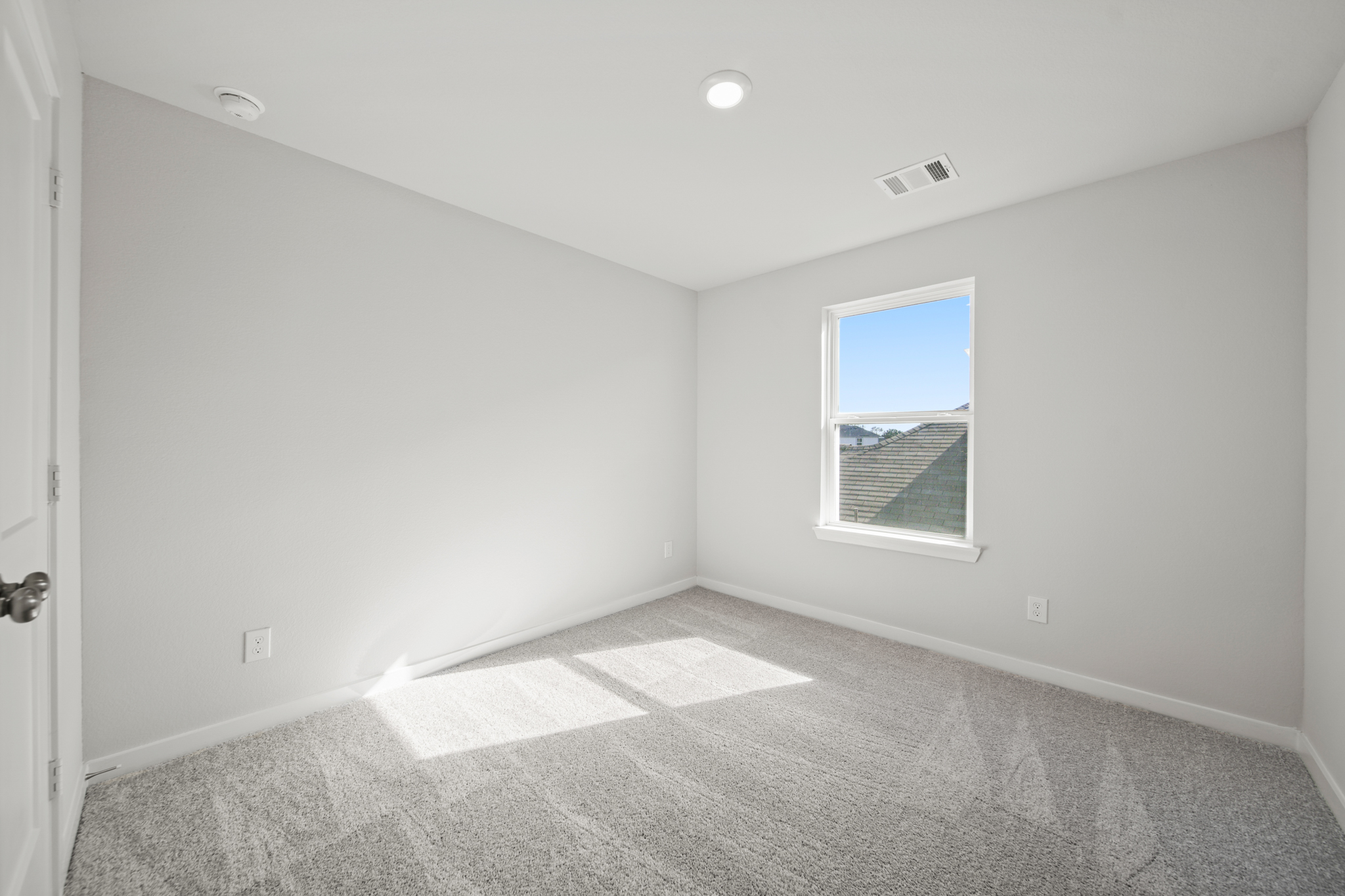 A room with a window and carpet.