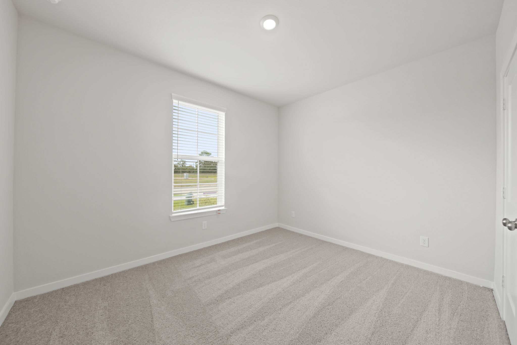 A room with a window and a carpet.