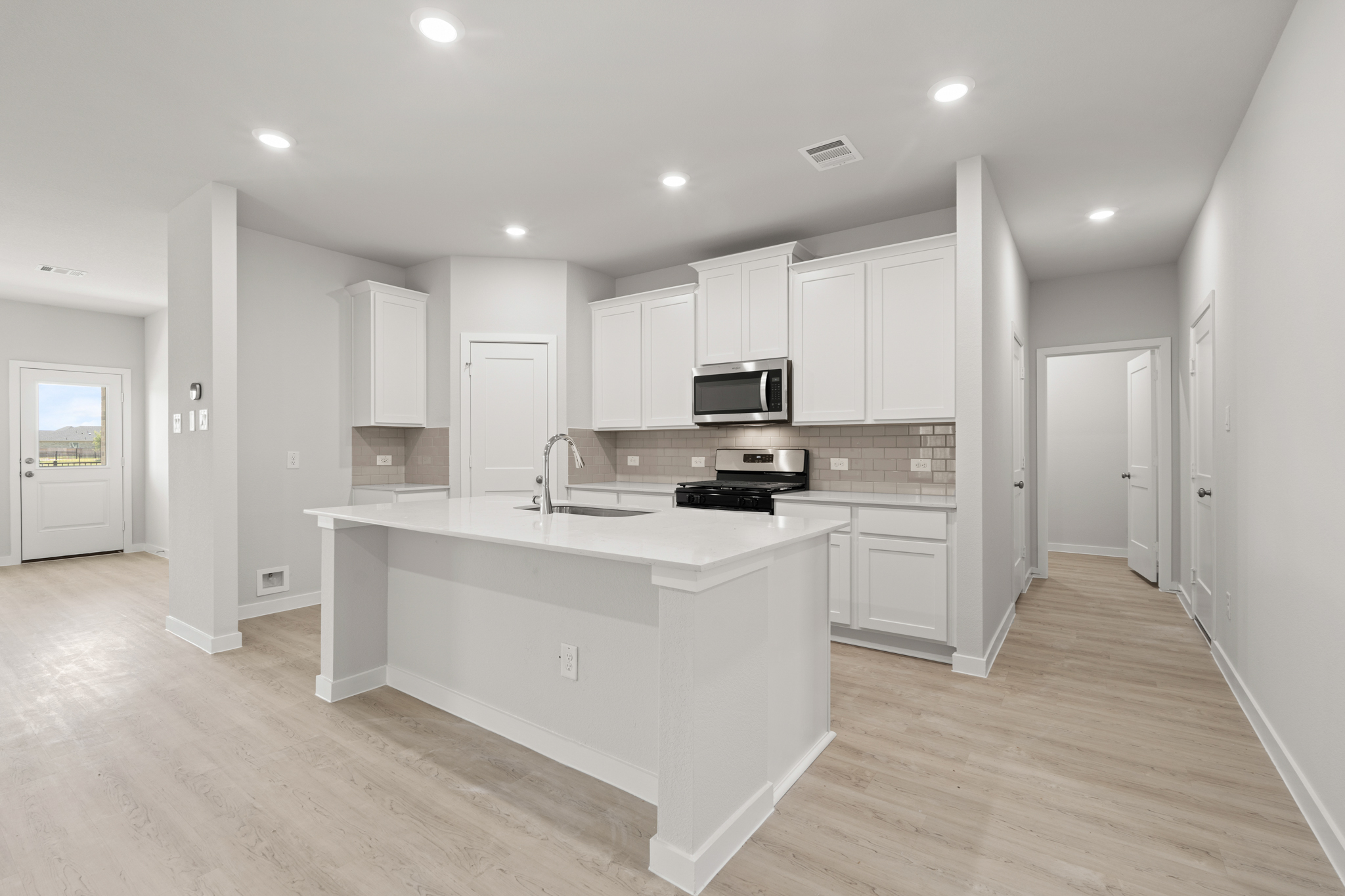 A kitchen with white cabinets.