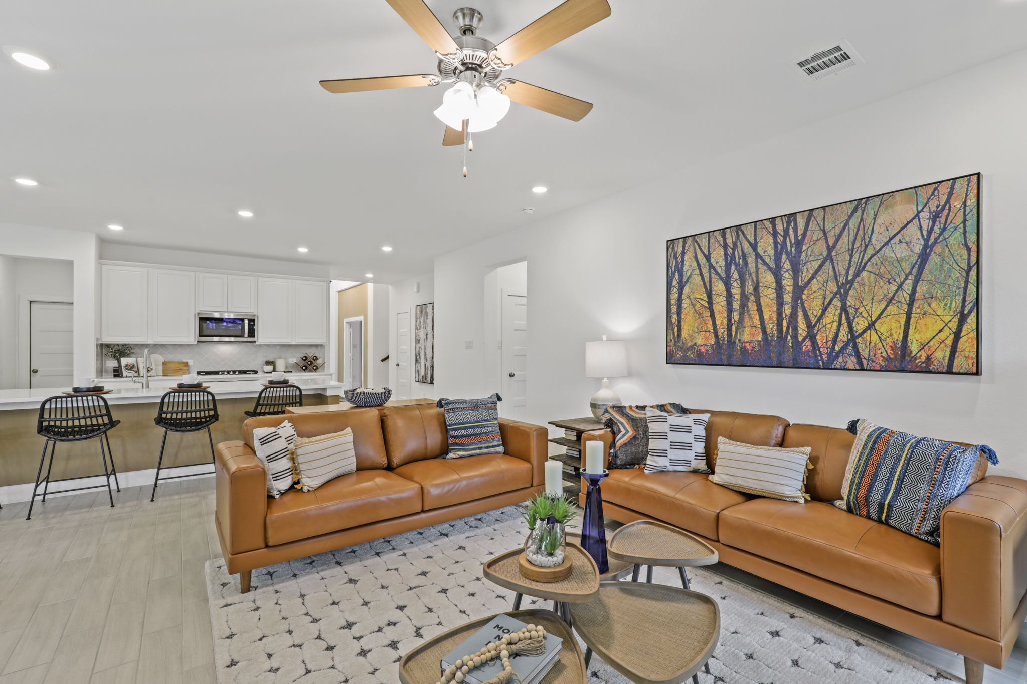 A living room with a couch and a fan.