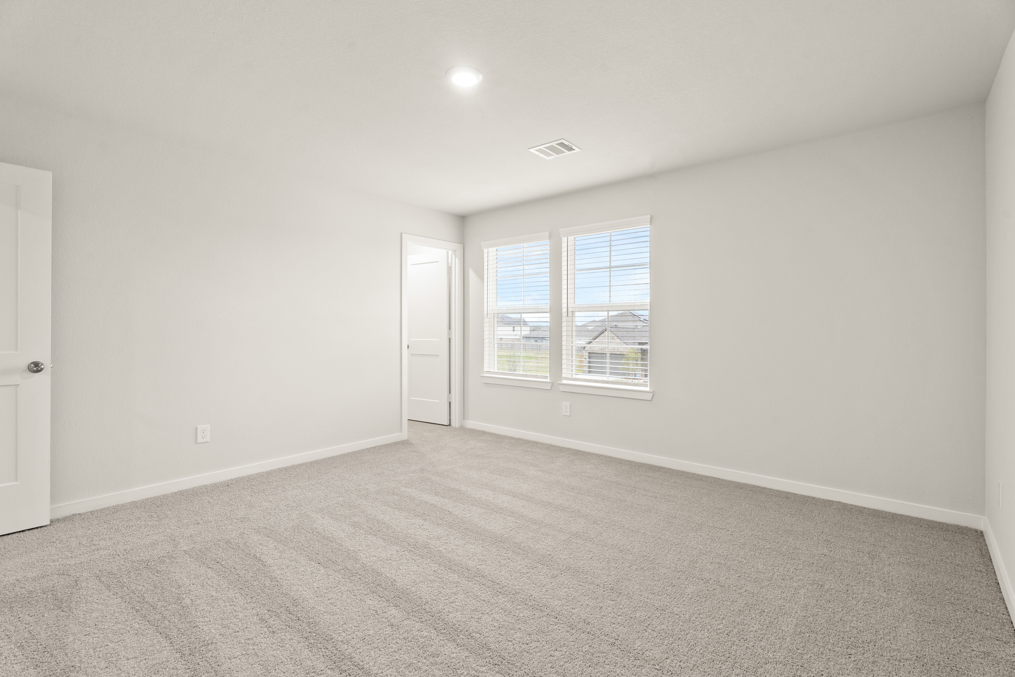 A room with a carpet and windows.