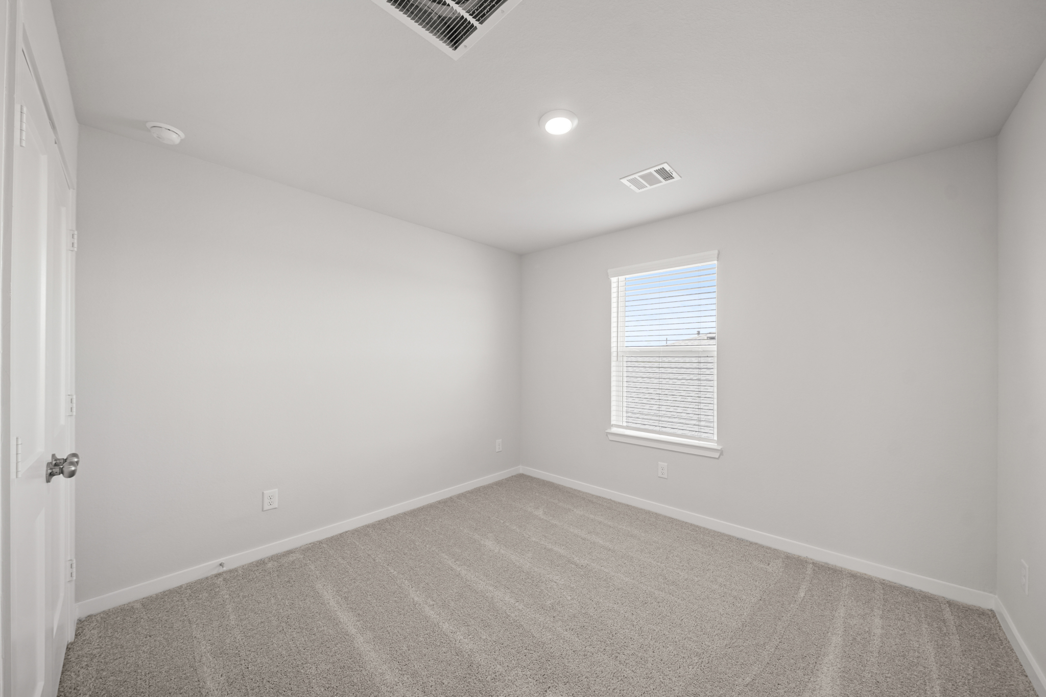 A room with a carpet and a door.