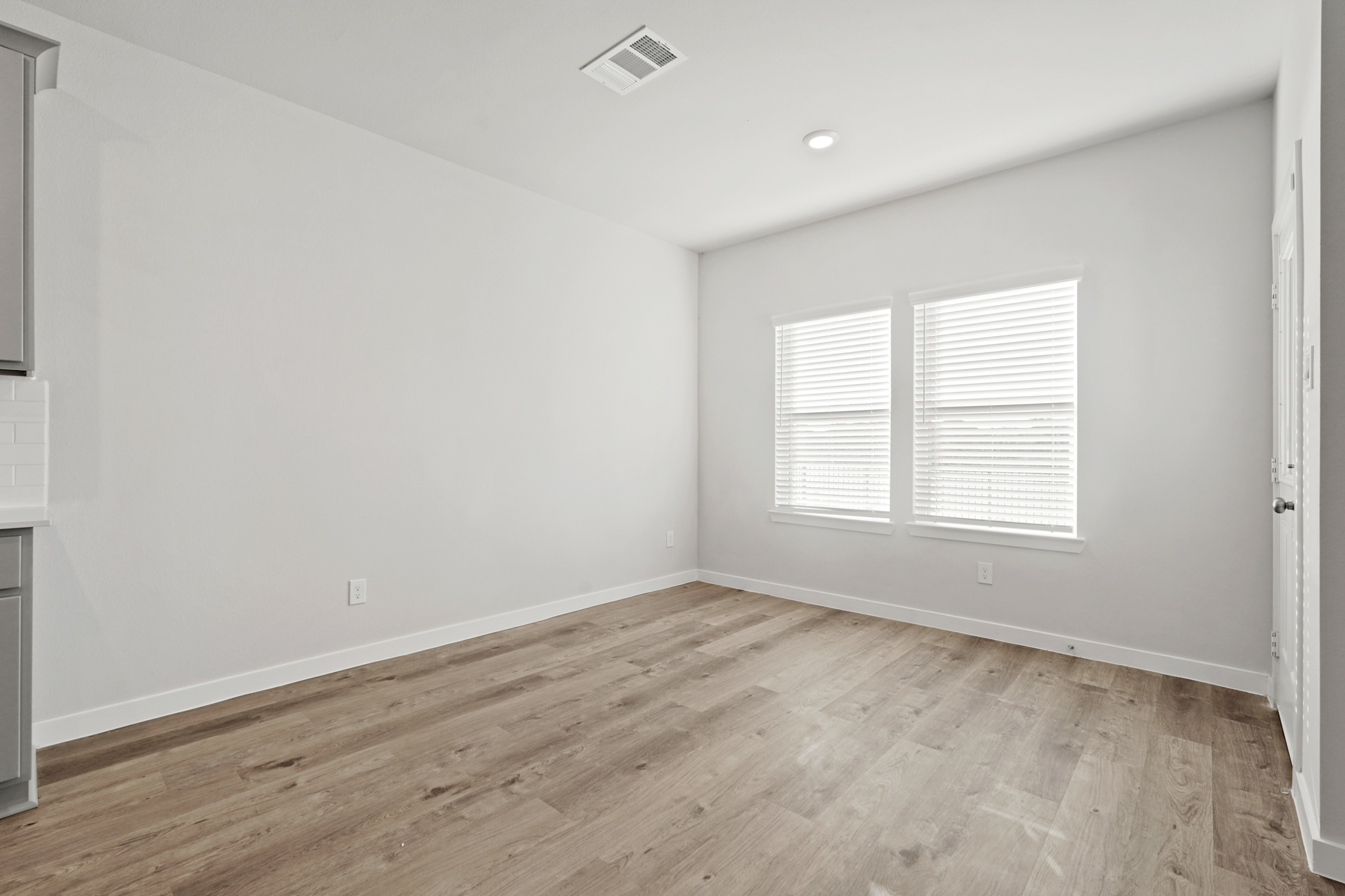 A room with a wood floor and white walls.