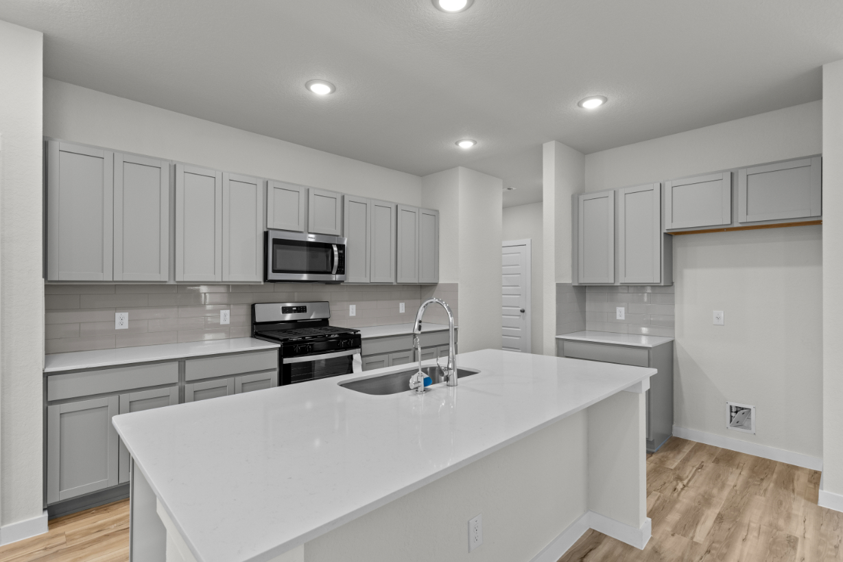A kitchen with white cabinets.