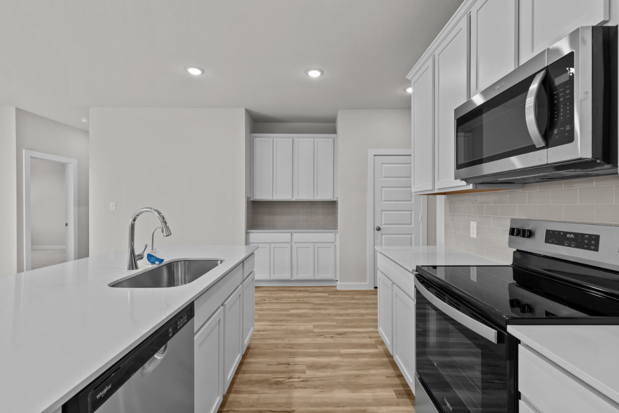 A kitchen with white cabinets.