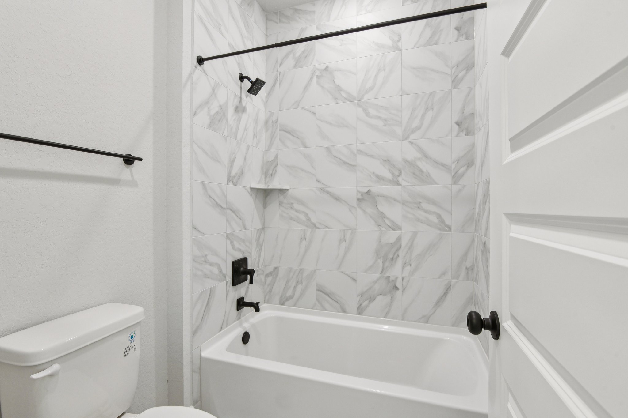 A bathtub and toilet in a bathroom.