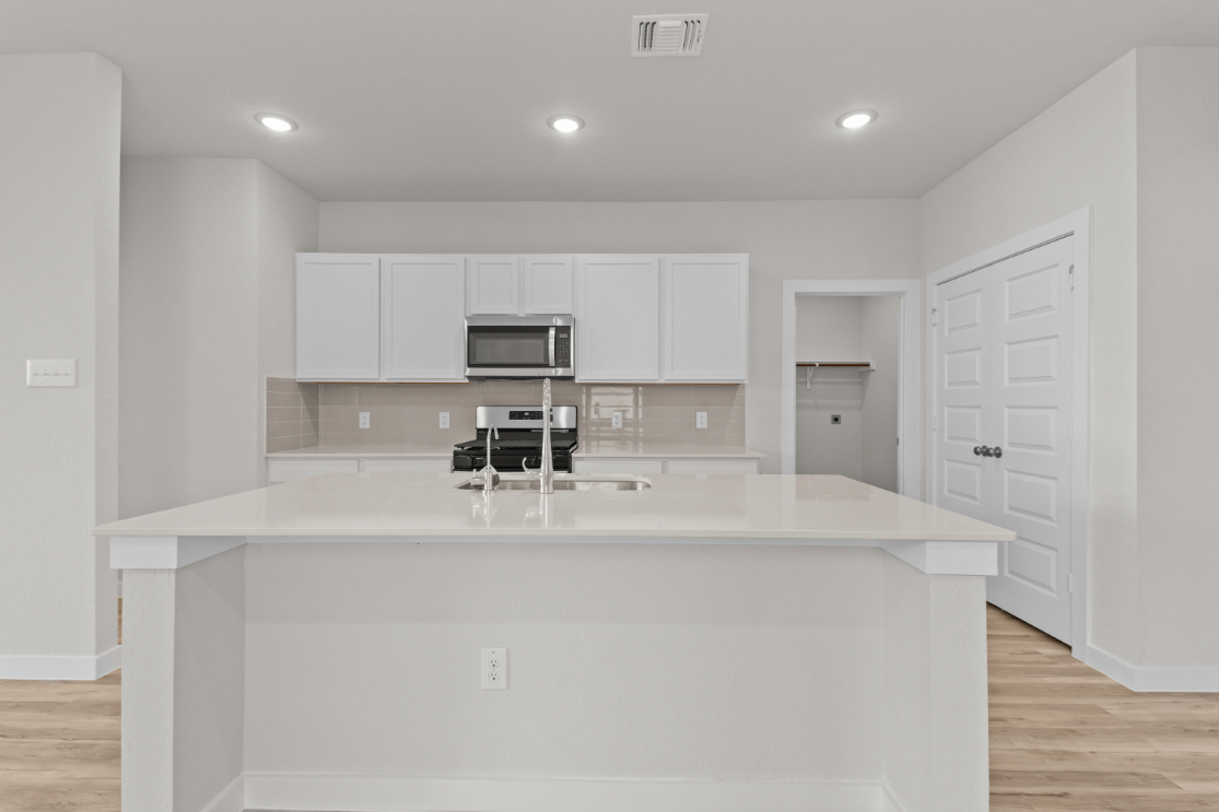 A kitchen with white cabinets.