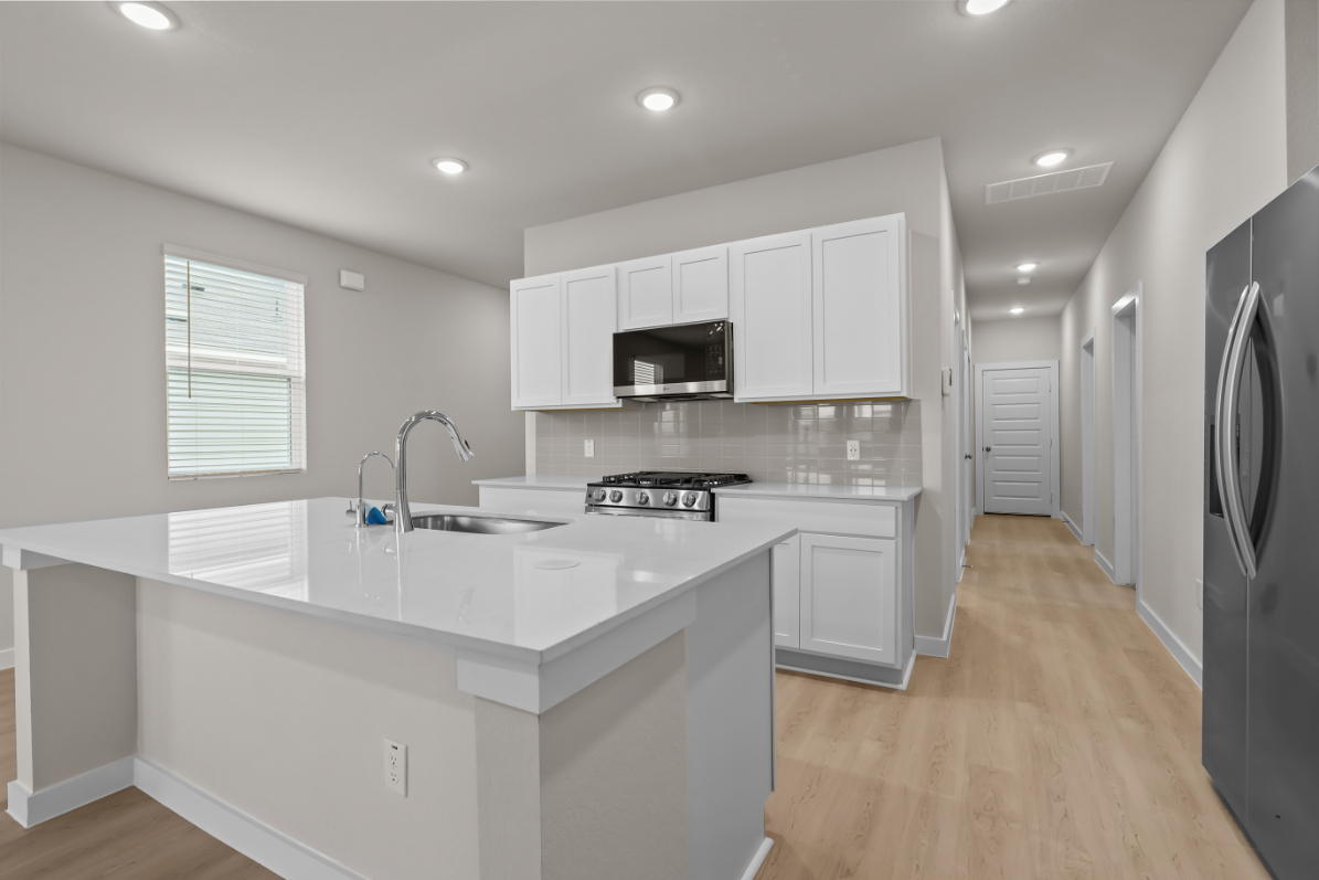 A kitchen with white cabinets.