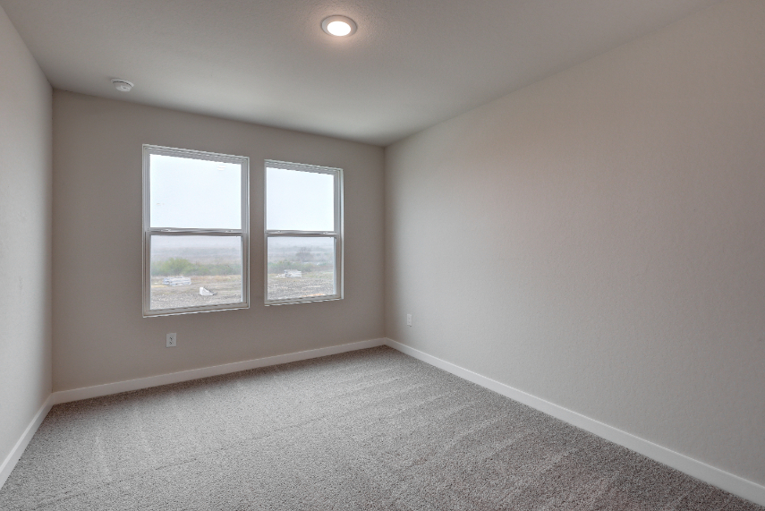 A room with a window and a carpet.