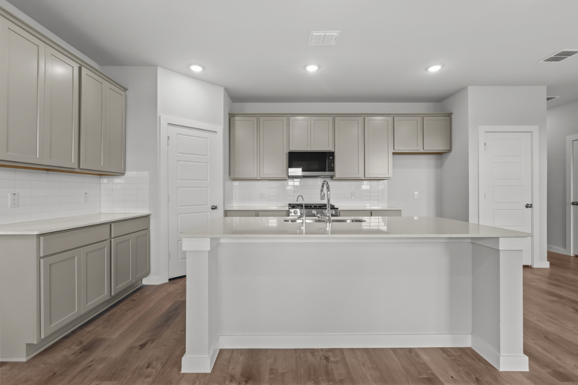 A kitchen with white cabinets.