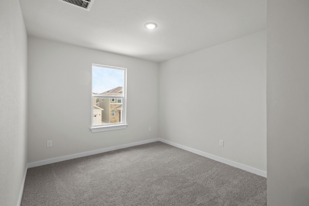 A room with a window and carpet.