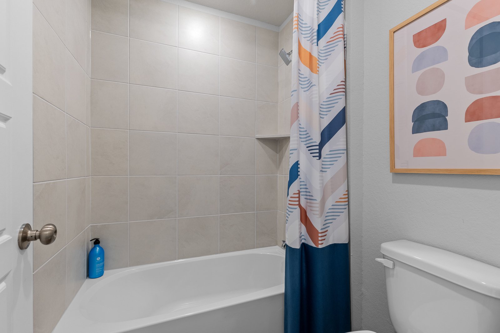 A bathroom with a blue shower curtain.